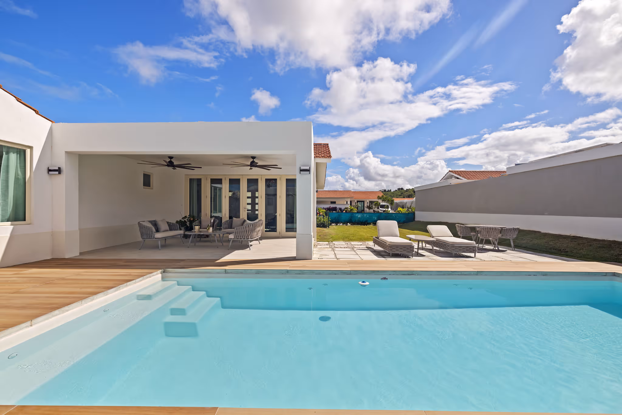 View of sunlit swimming pool and contemporary outdoor living space in Sabanera Dorado luxury property