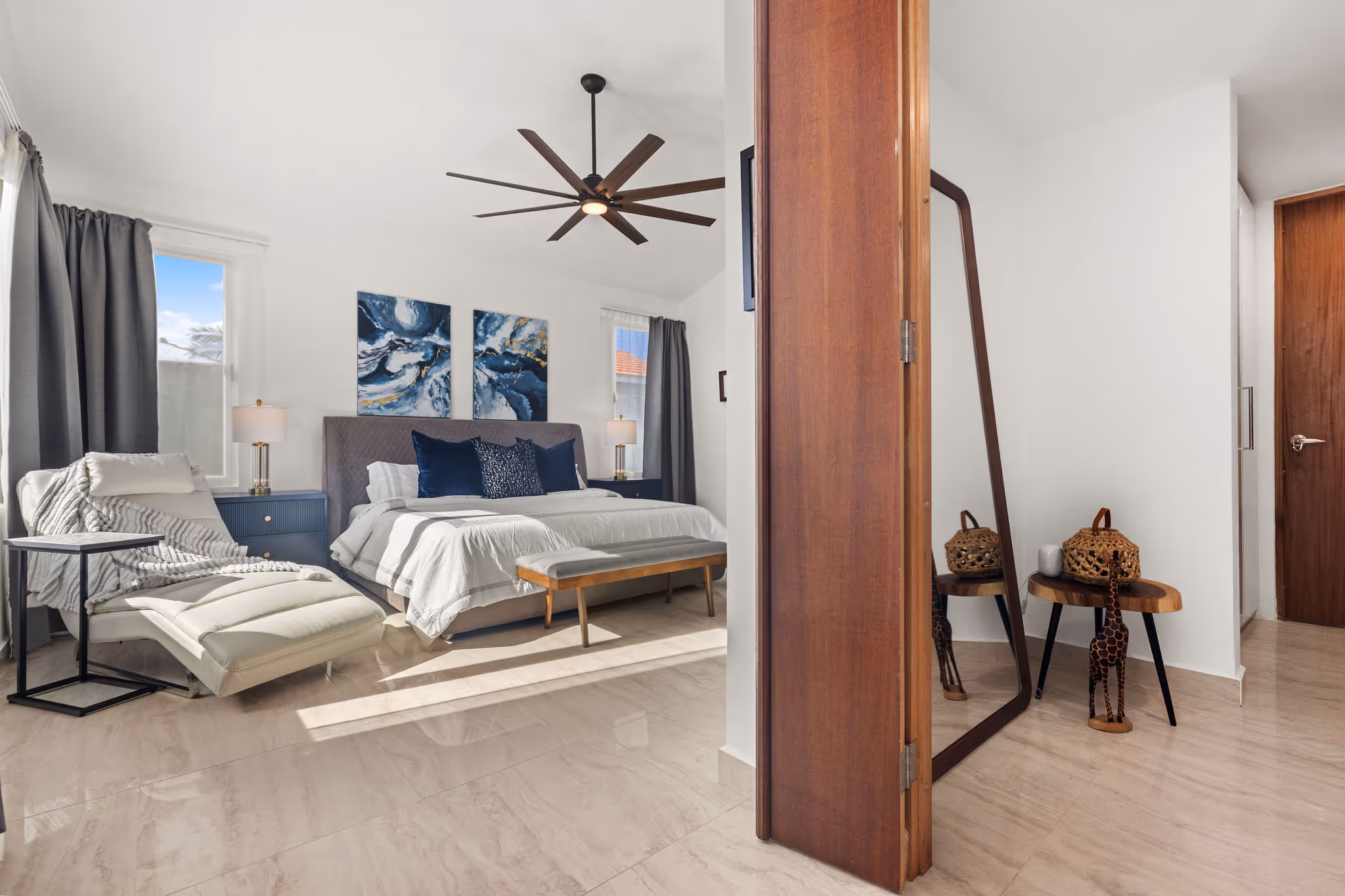 Bright and serene master bedroom with chaise lounge and designer touches in Sabanera Dorado home
