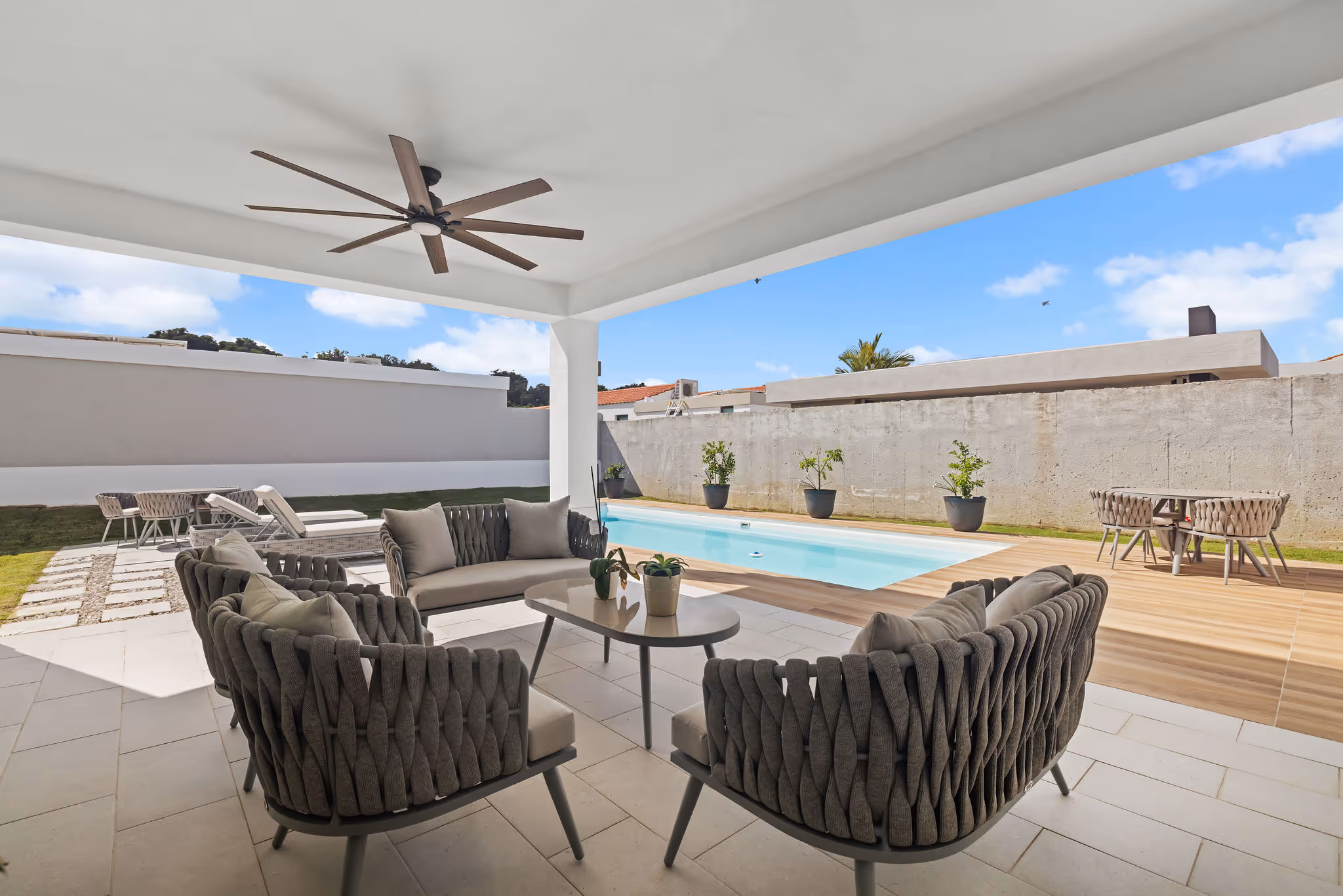Covered outdoor lounge with pool view and ceiling fans in eco-conscious Sabanera Dorado property