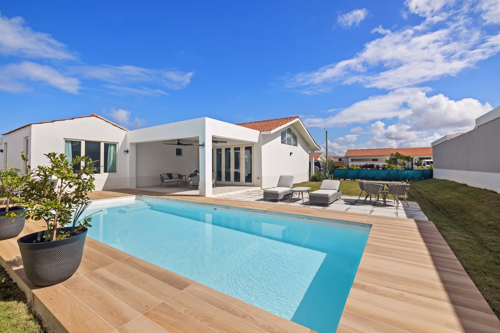 Modern tropical backyard with pool, shaded patio, and lounging space in Isla de las Flores eco-home