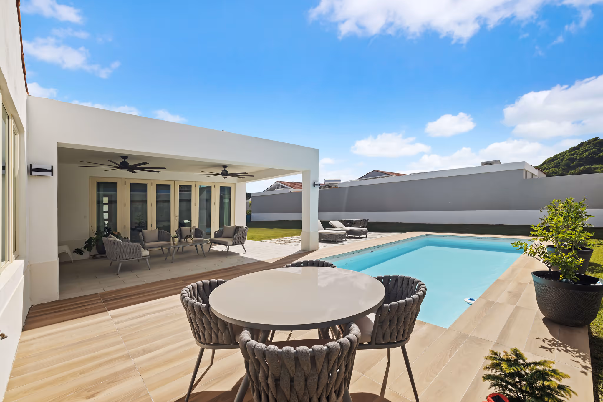 Elegant poolside dining area next to covered terrace in sustainable residence at Isla de las Flores