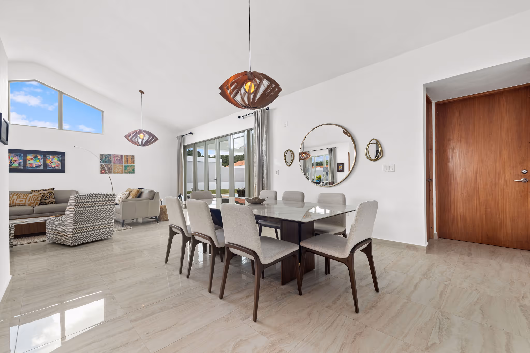 Contemporary dining room with wall mirrors and access to outdoor patio in luxury Dorado residence