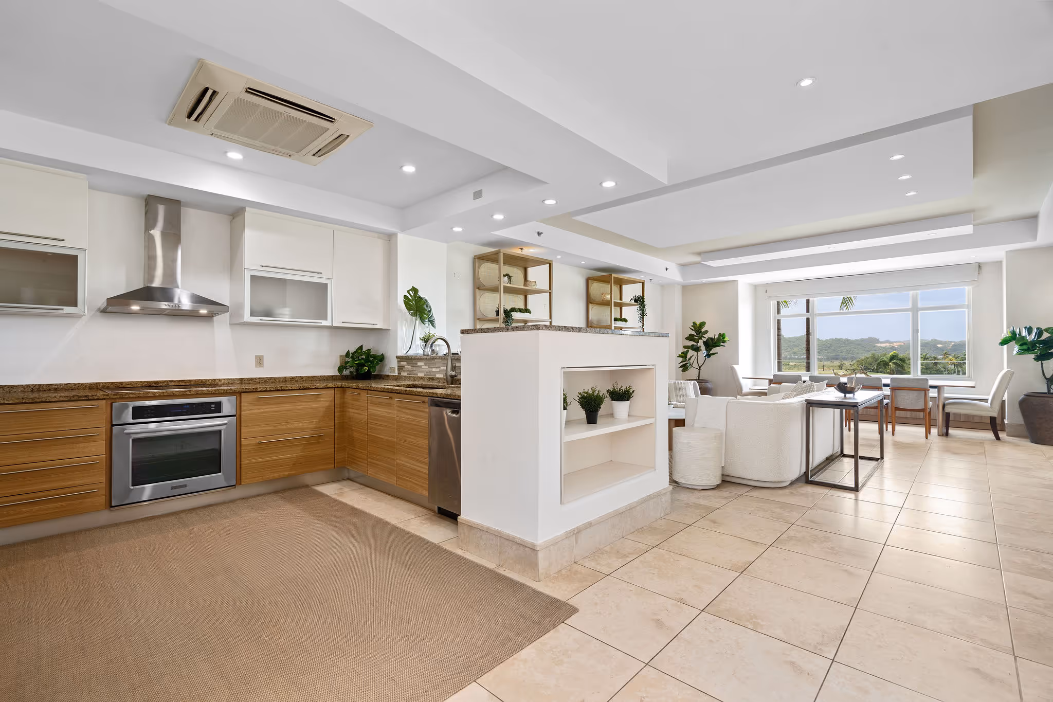 Modern open-concept kitchen with stainless steel appliances and granite countertops at Plantation Village in Dorado Beach Resort