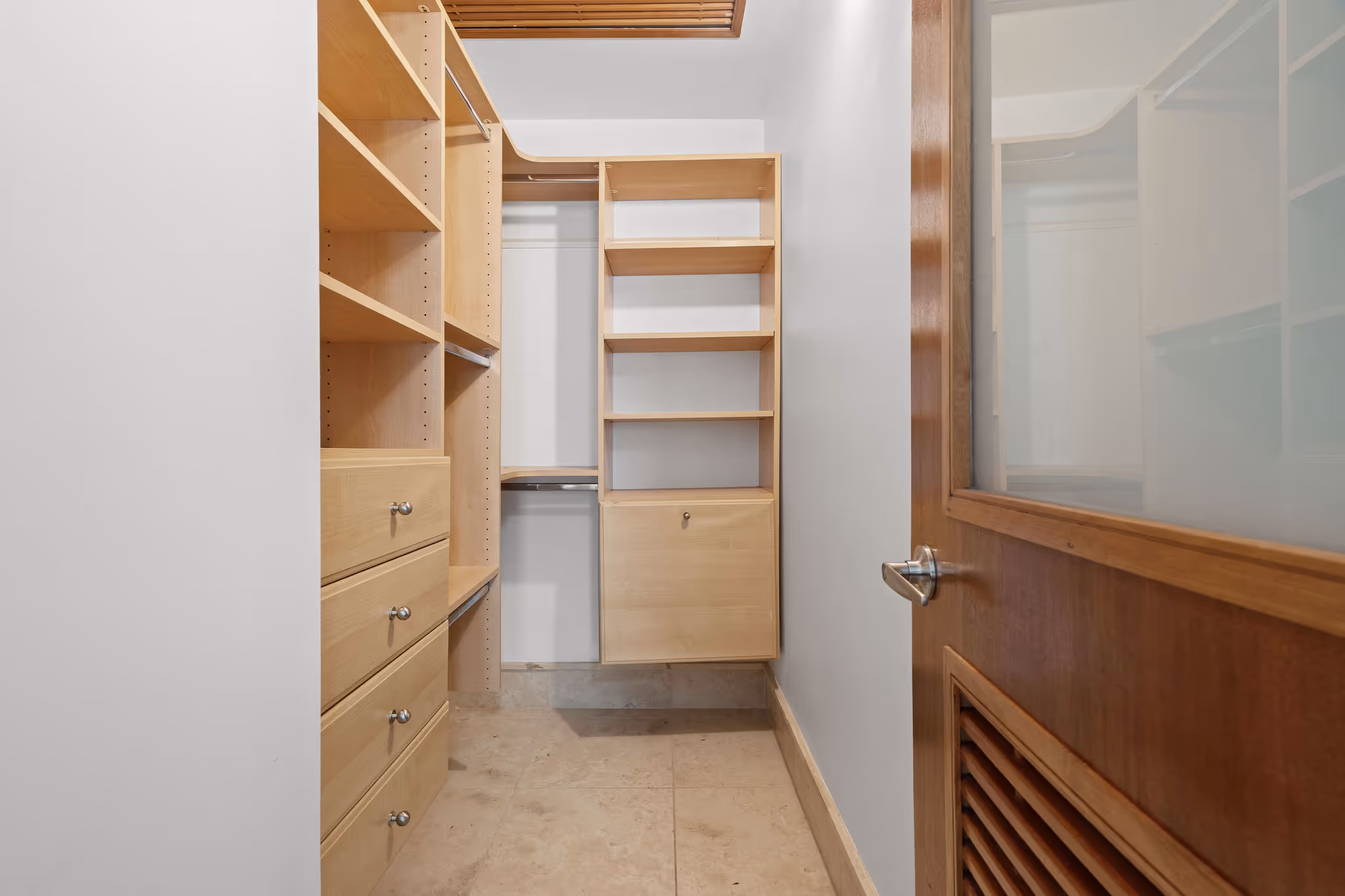 Second walk-in closet with light wood built-ins and drawers in upscale Dorado Beach Resort condo