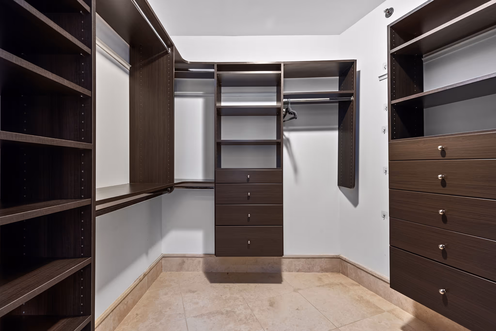 Spacious walk-in closet with dark custom cabinetry and ample shelving in luxury Dorado Beach Plantation Village condo