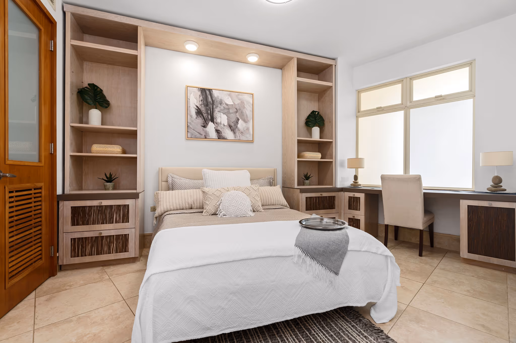 Guest bedroom with built-in shelving, work desk, and cozy design in Plantation Village Dorado Beach residence