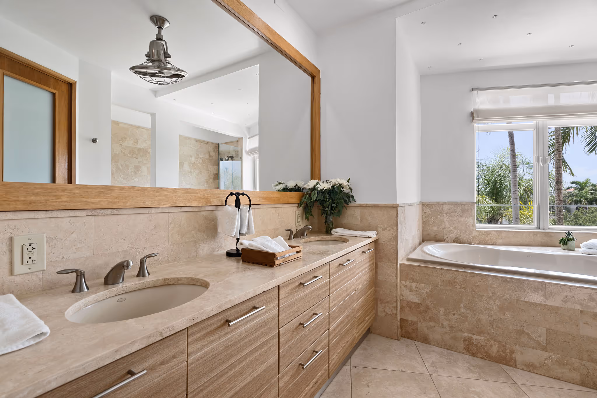En-suite bathroom with double sinks and soaking tub overlooking palm trees in Dorado Beach Resort condo