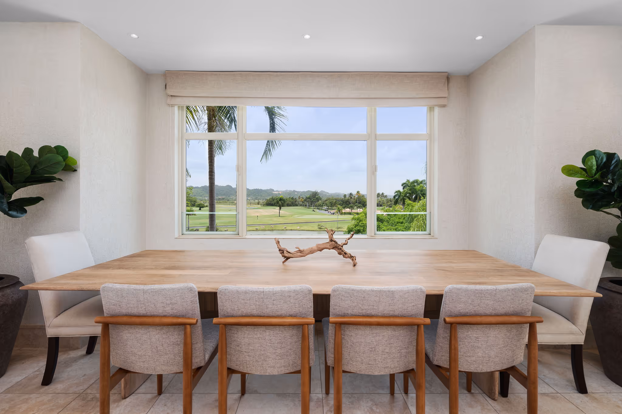 Expansive dining area with floor-to-ceiling windows overlooking golf course and tropical landscaping in Dorado Beach condo