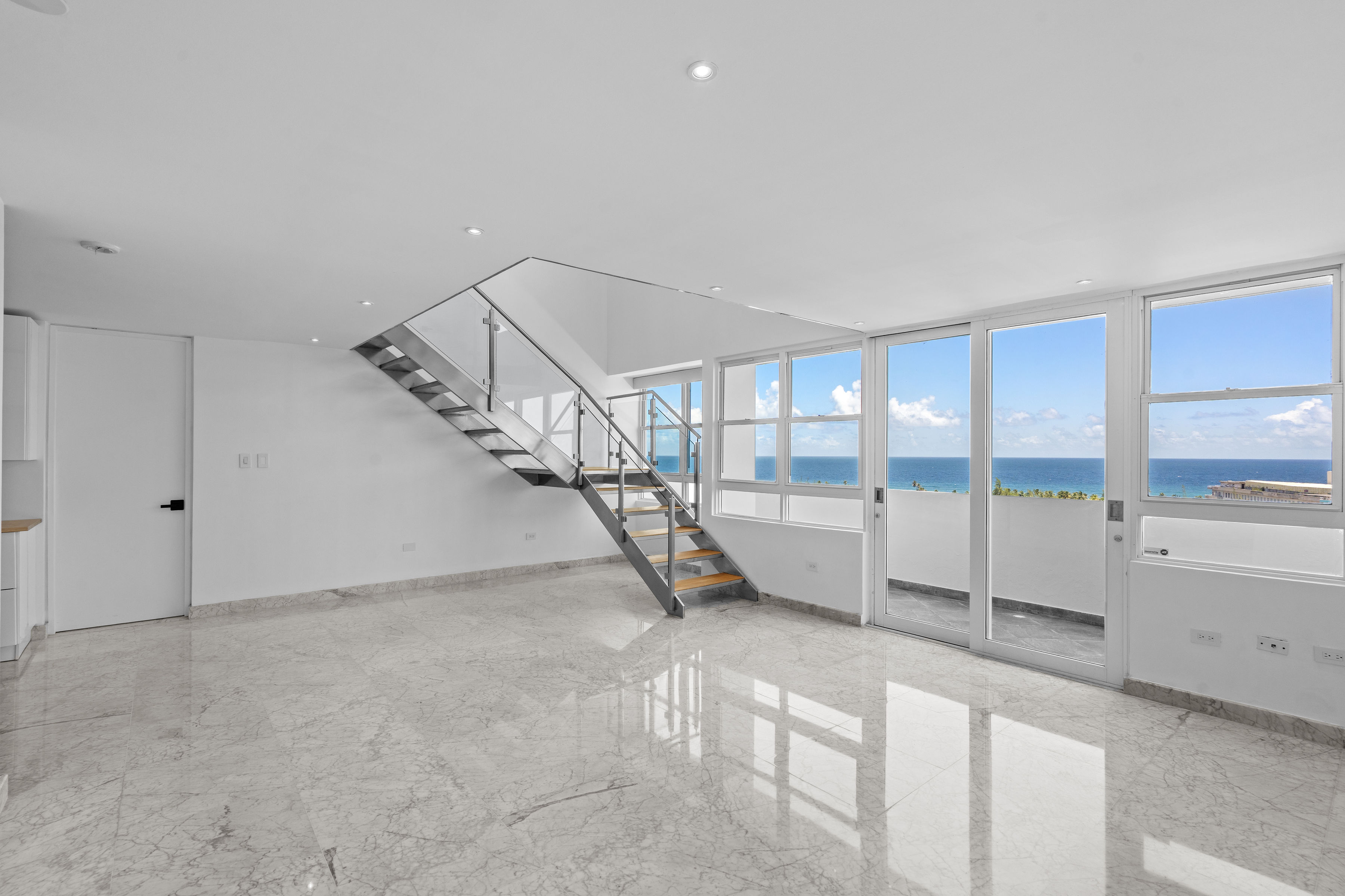 Remodeled San Juan penthouse living room with expansive interiors and dining area