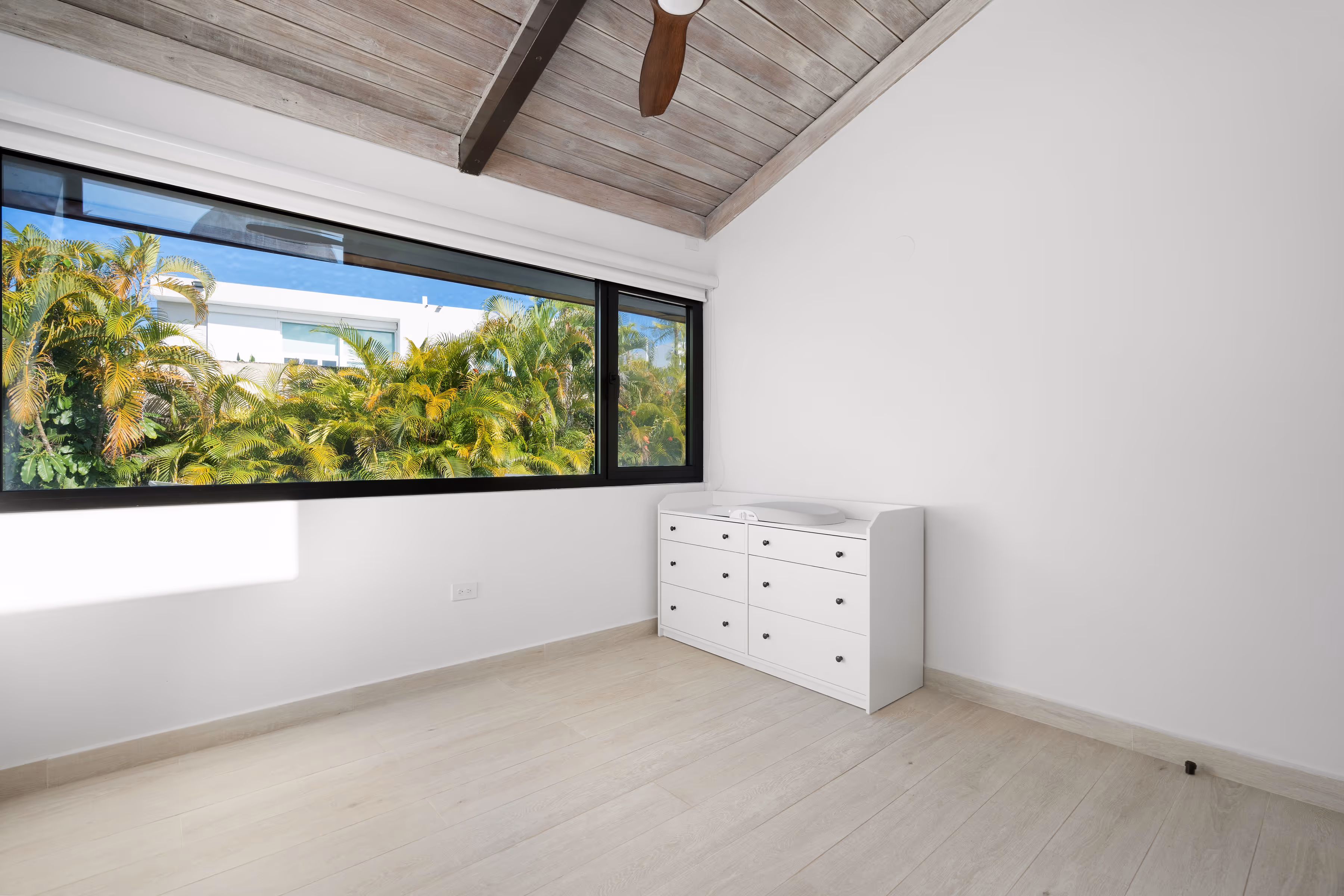 Spacious bedroom with high wood ceilings and natural light