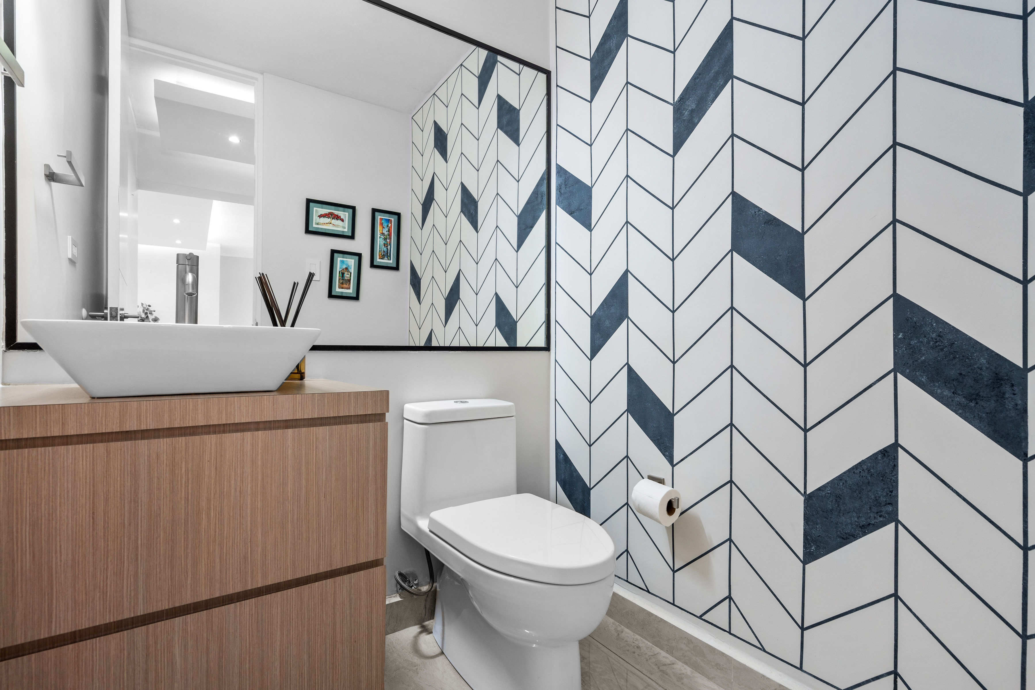 Astralis Residences powder room with modern vanity vessel sink and geometric accent wall