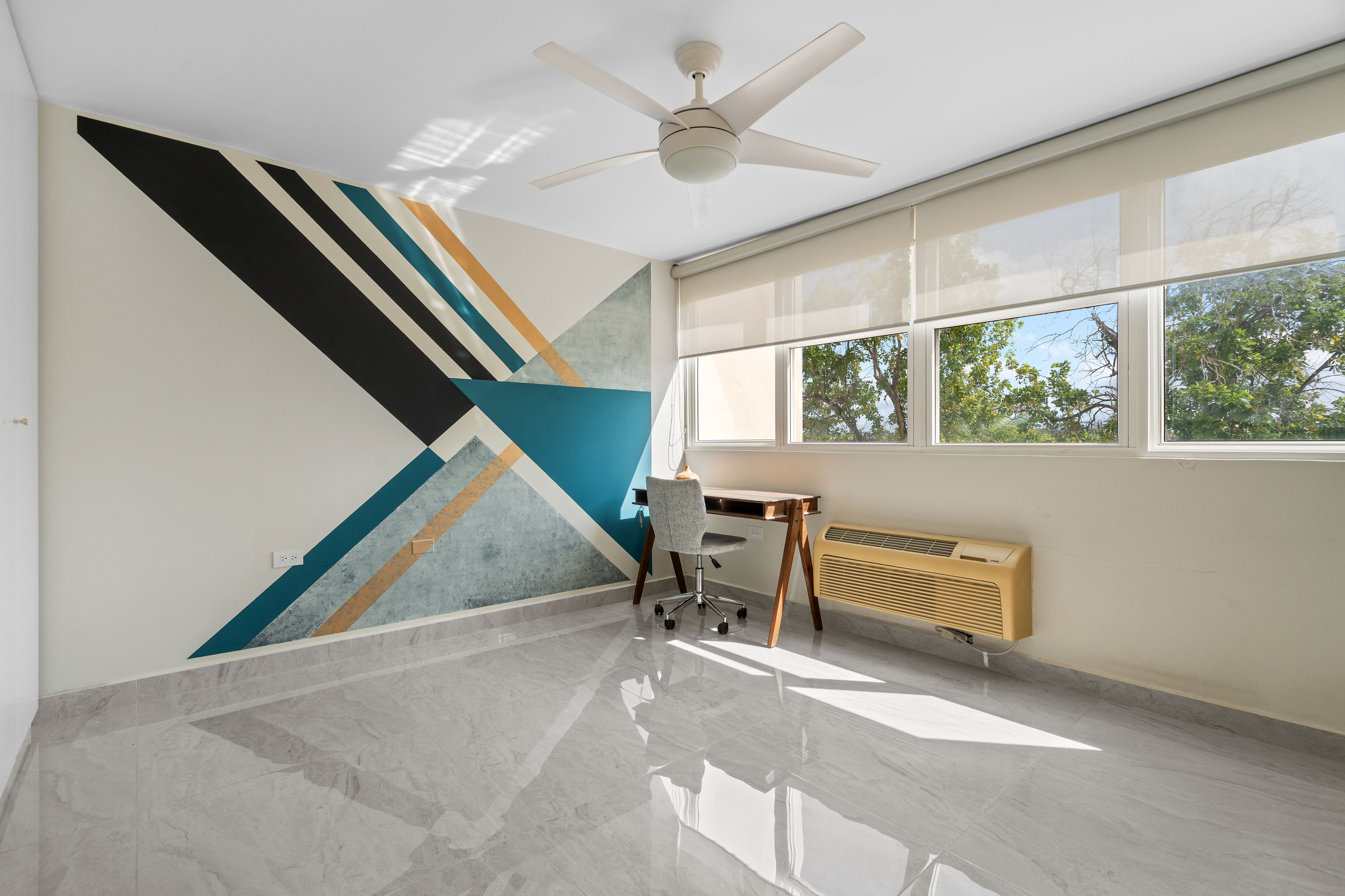 Astralis Isla Verde bedroom or office space with geometric accent wall desk setup and natural light
