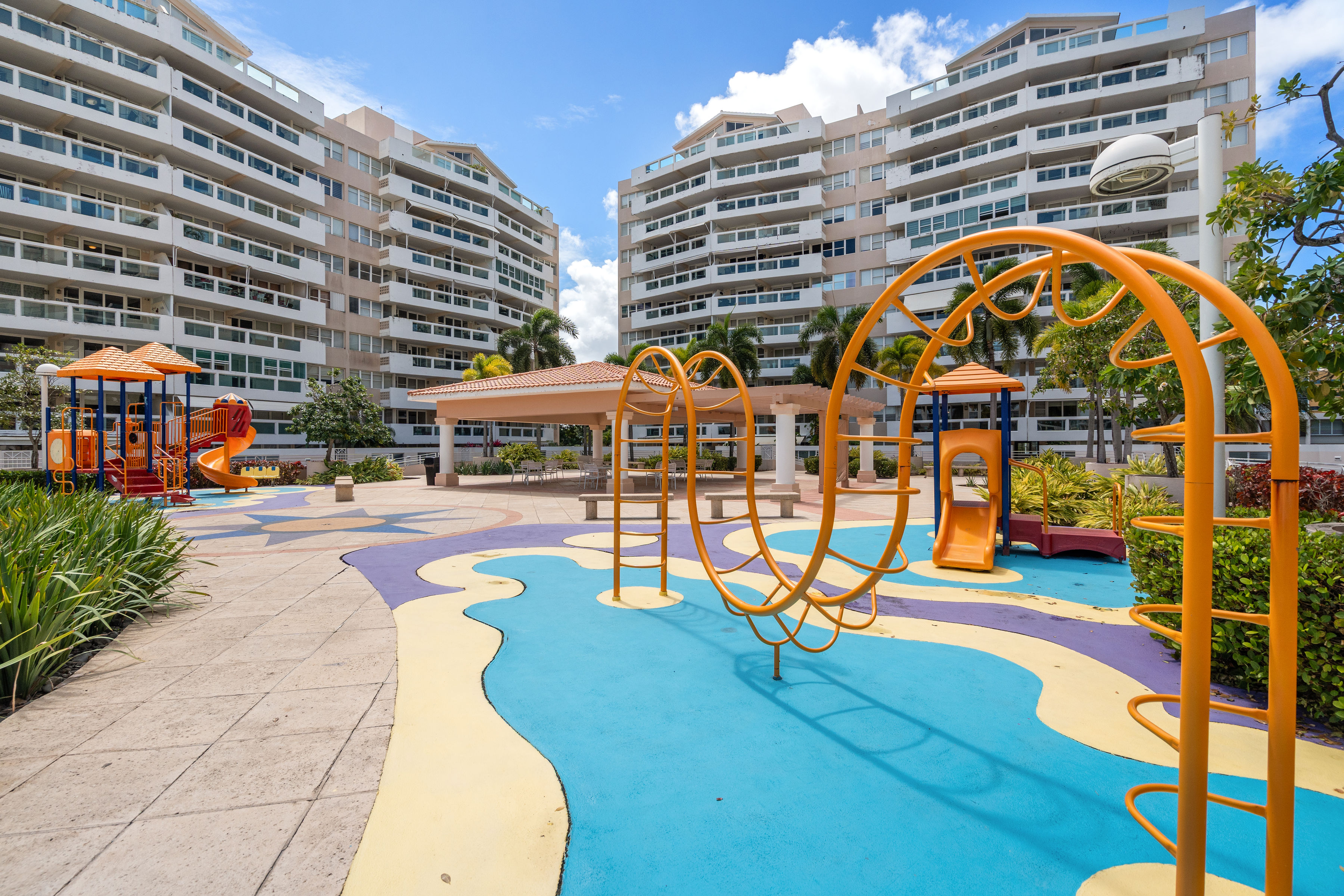 Astralis Isla Verde children playground with colorful equipment and open community courtyard