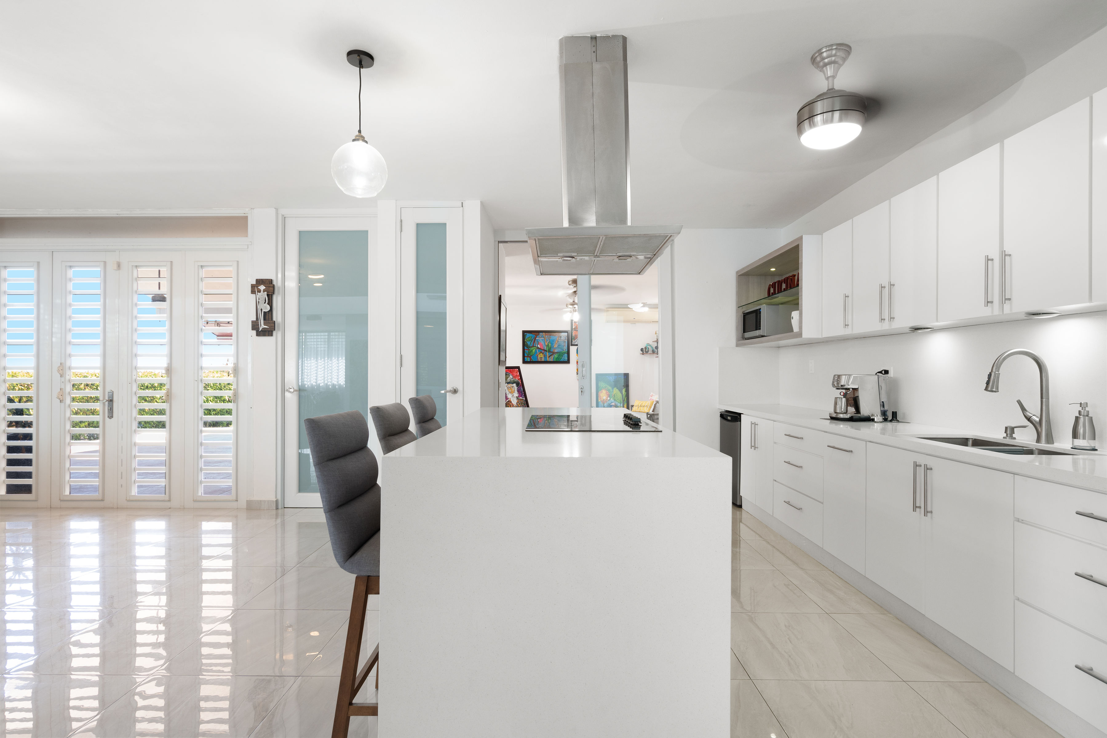 Kitchen with quartz countertops, custom cabinetry and open layout in Mansiones de Villanova