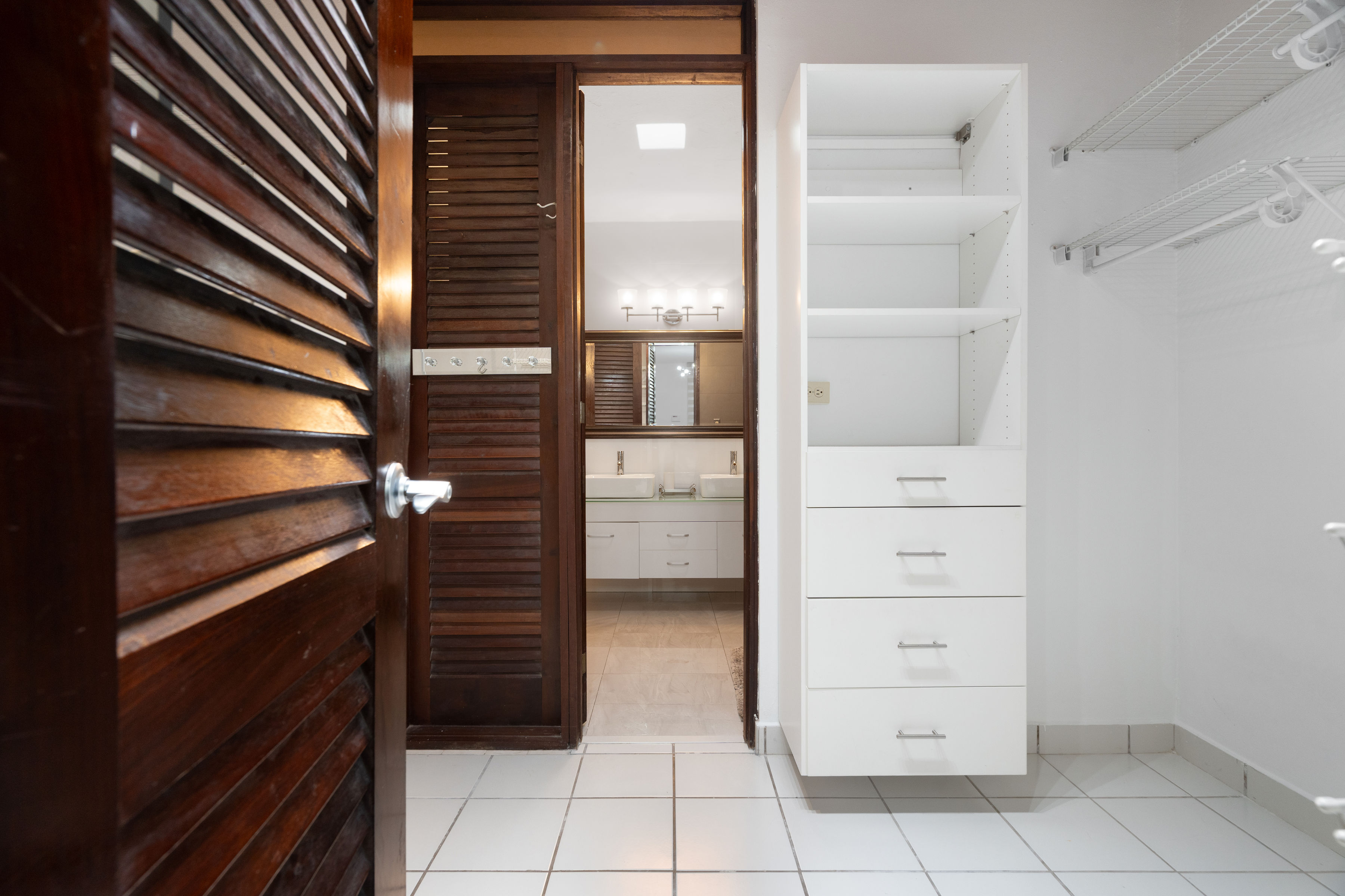 Walk in closet with built in storage and access to primary bathroom in Mansiones de Villanova