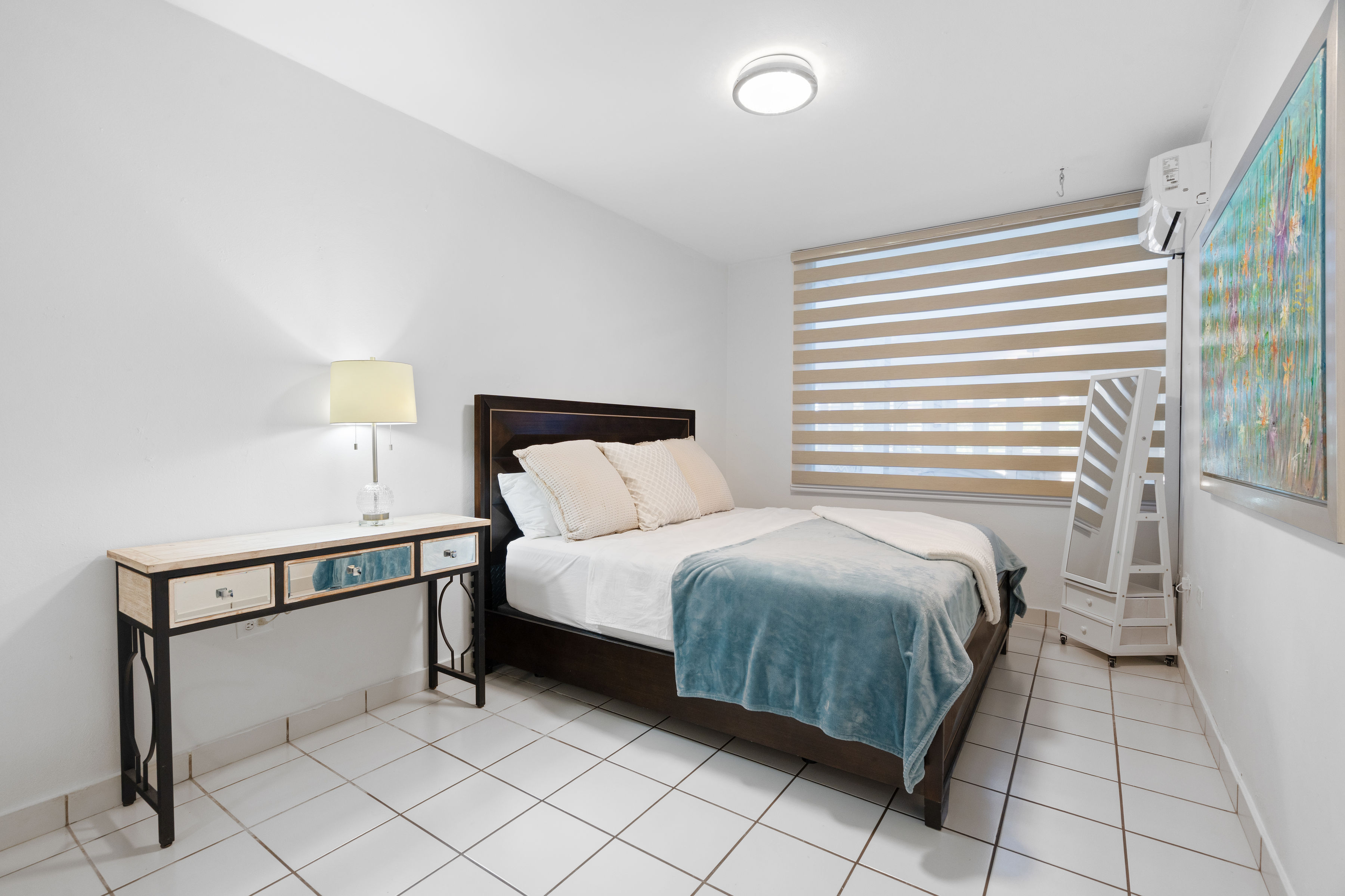 Bedroom with queen bed, desk console and soft lighting in Mansiones de Villanova residence