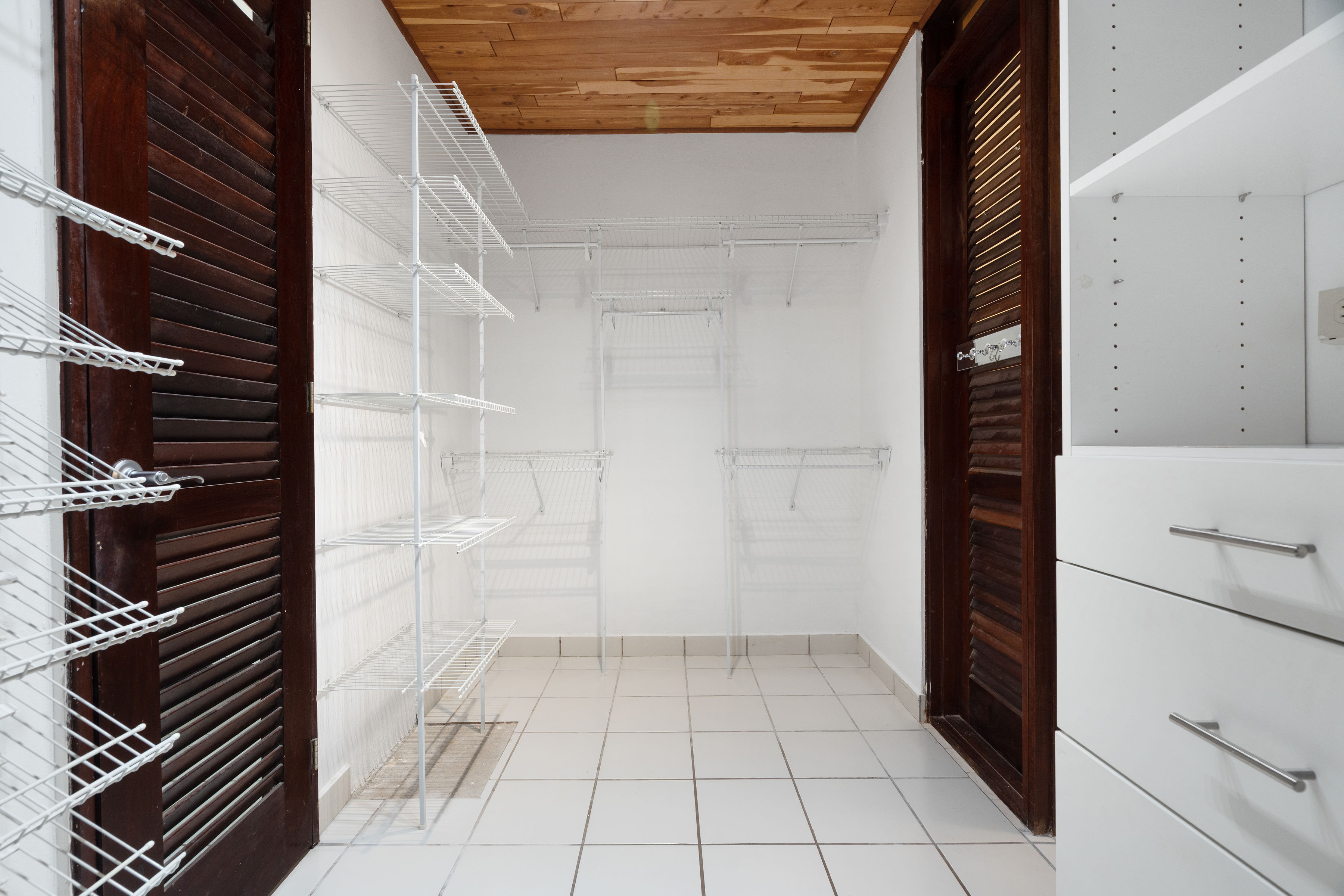 Spacious walk in closet with shelving and storage system in San Juan residence