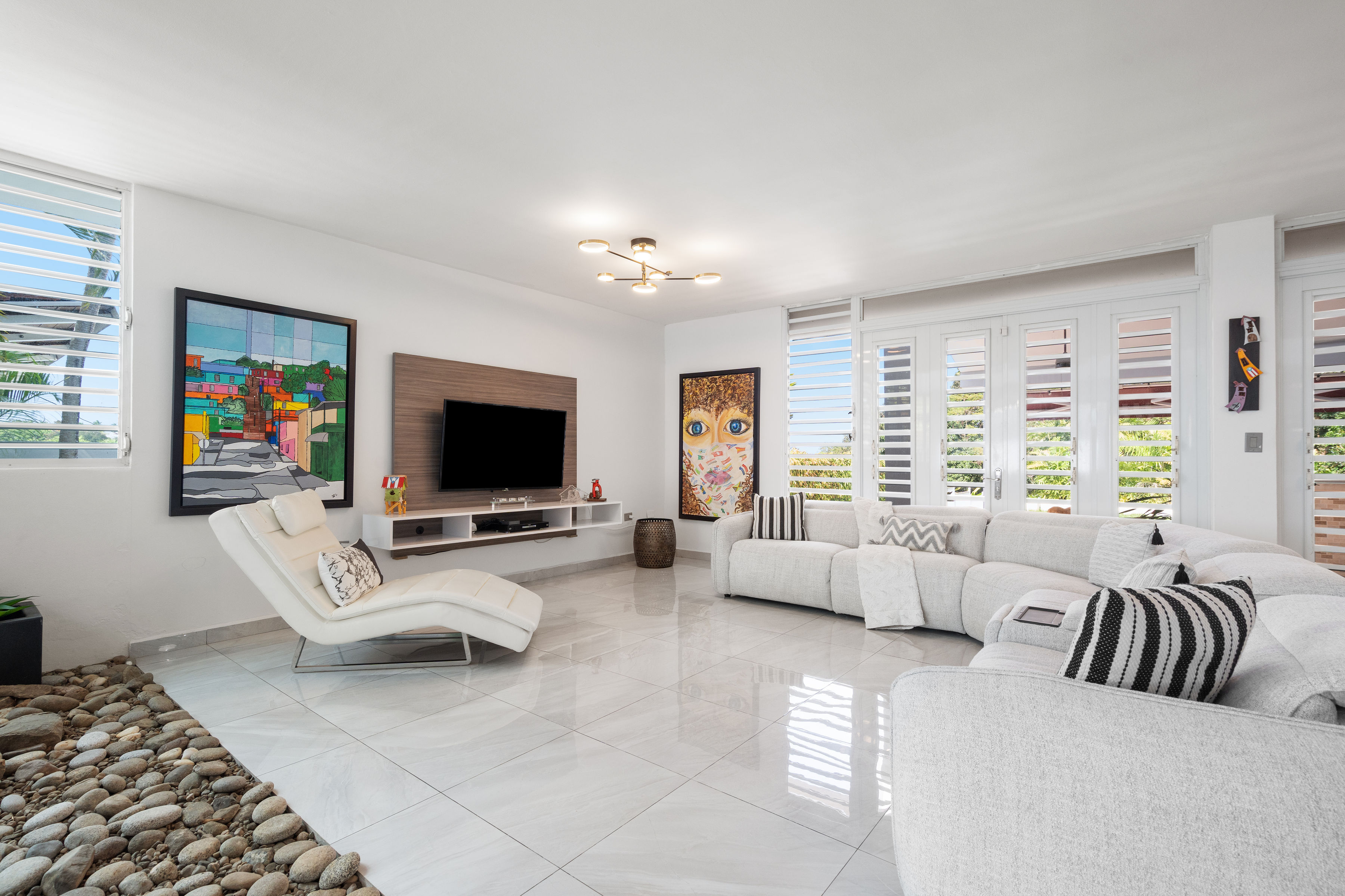 Family room with large sectional sofa and outdoor access in Mansiones de Villanova home