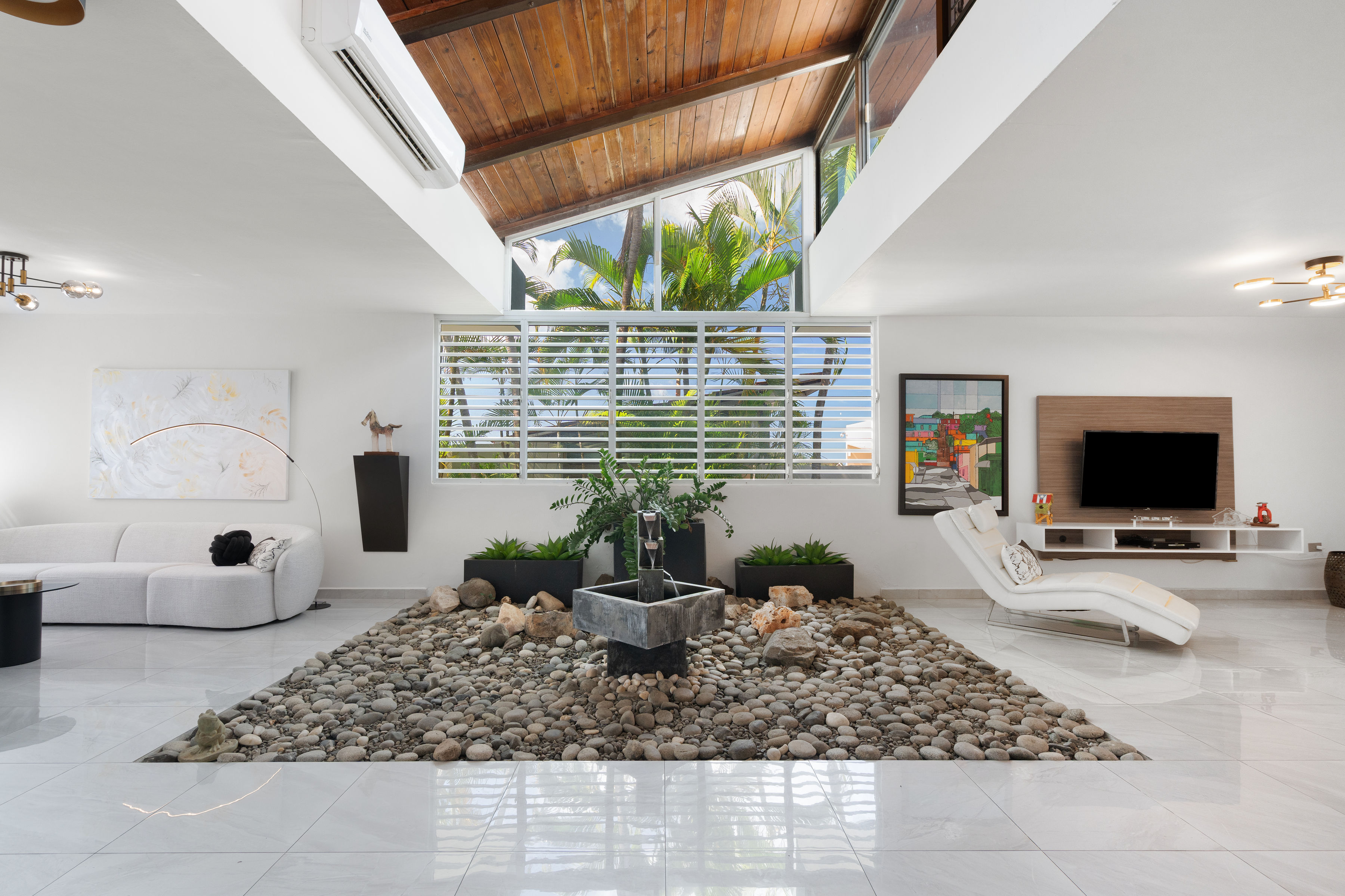 Indoor garden with stone feature and fountain under high ceilings in San Juan luxury home
