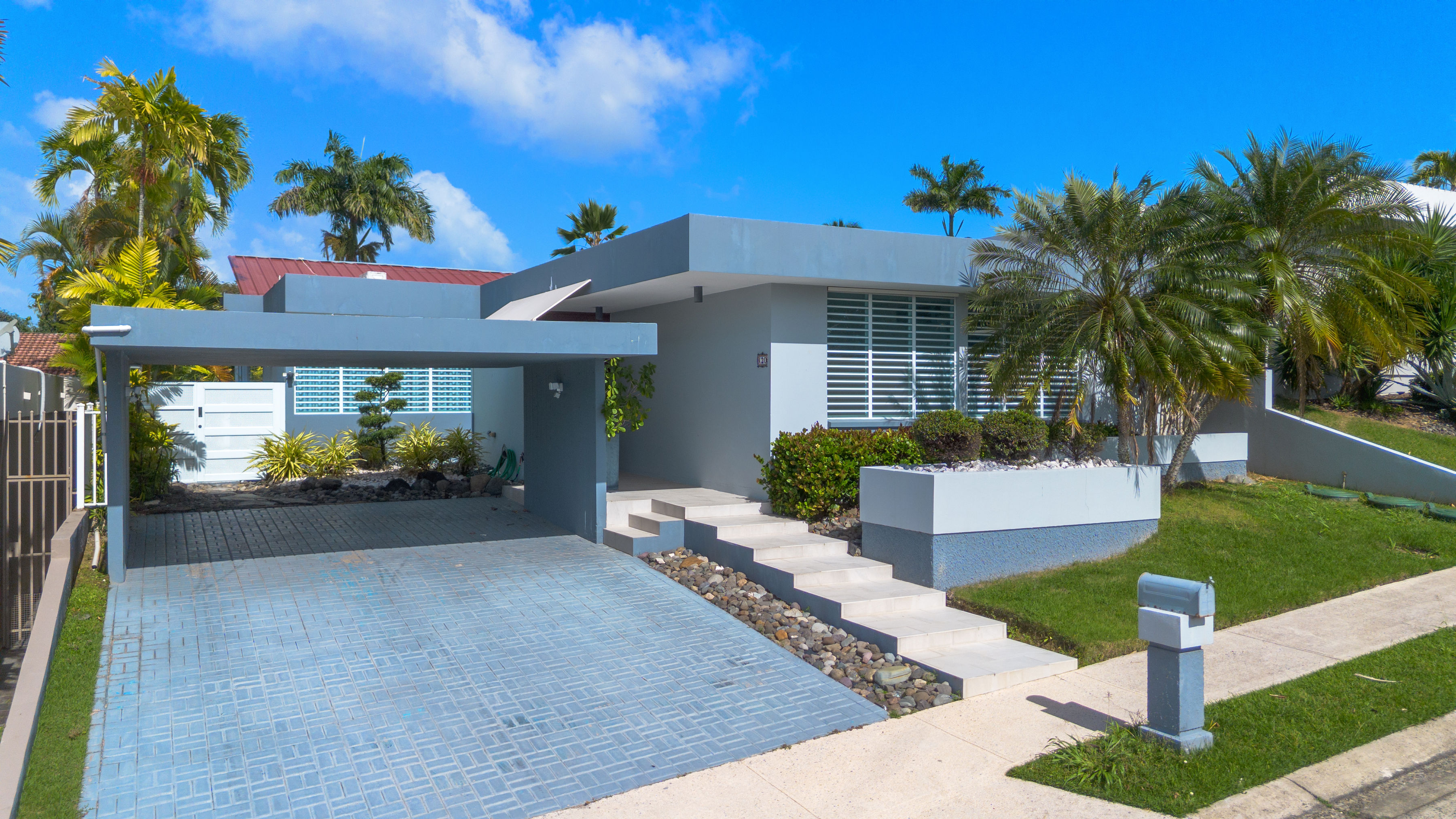 Modern single story home exterior with covered carport and landscaped front yard in San Juan