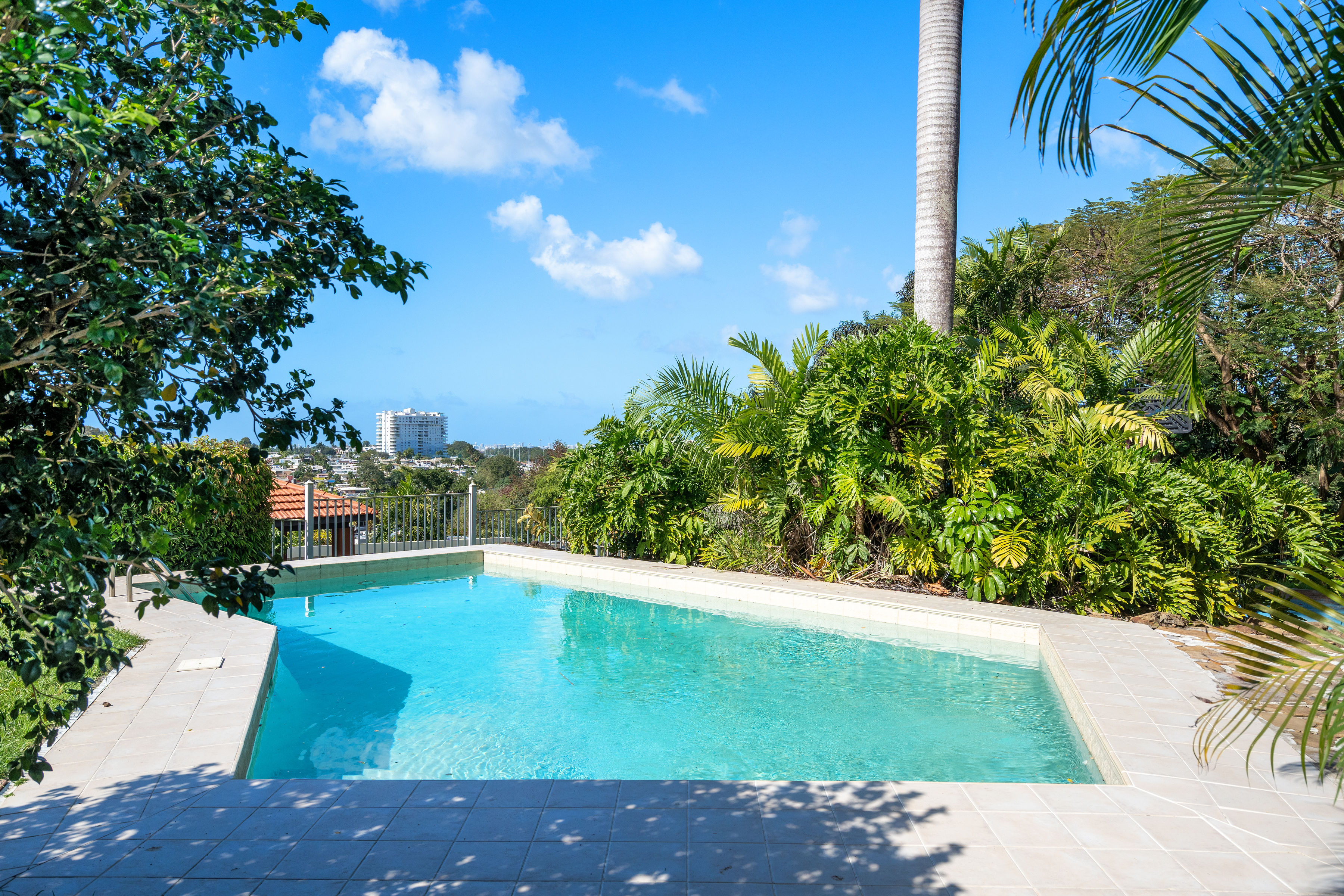Private backyard pool with lush greenery and open views in Mansiones de Villanova San Juan