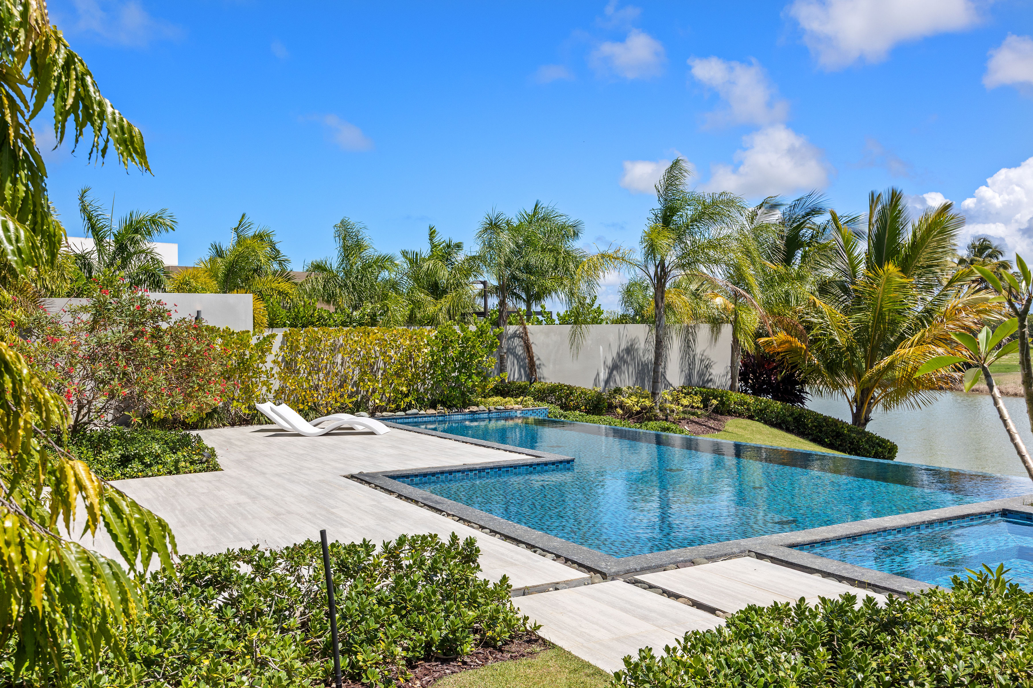 Dorado Beach Resort The Isles residence poolside terrace with lounge chairs and tropical landscaping