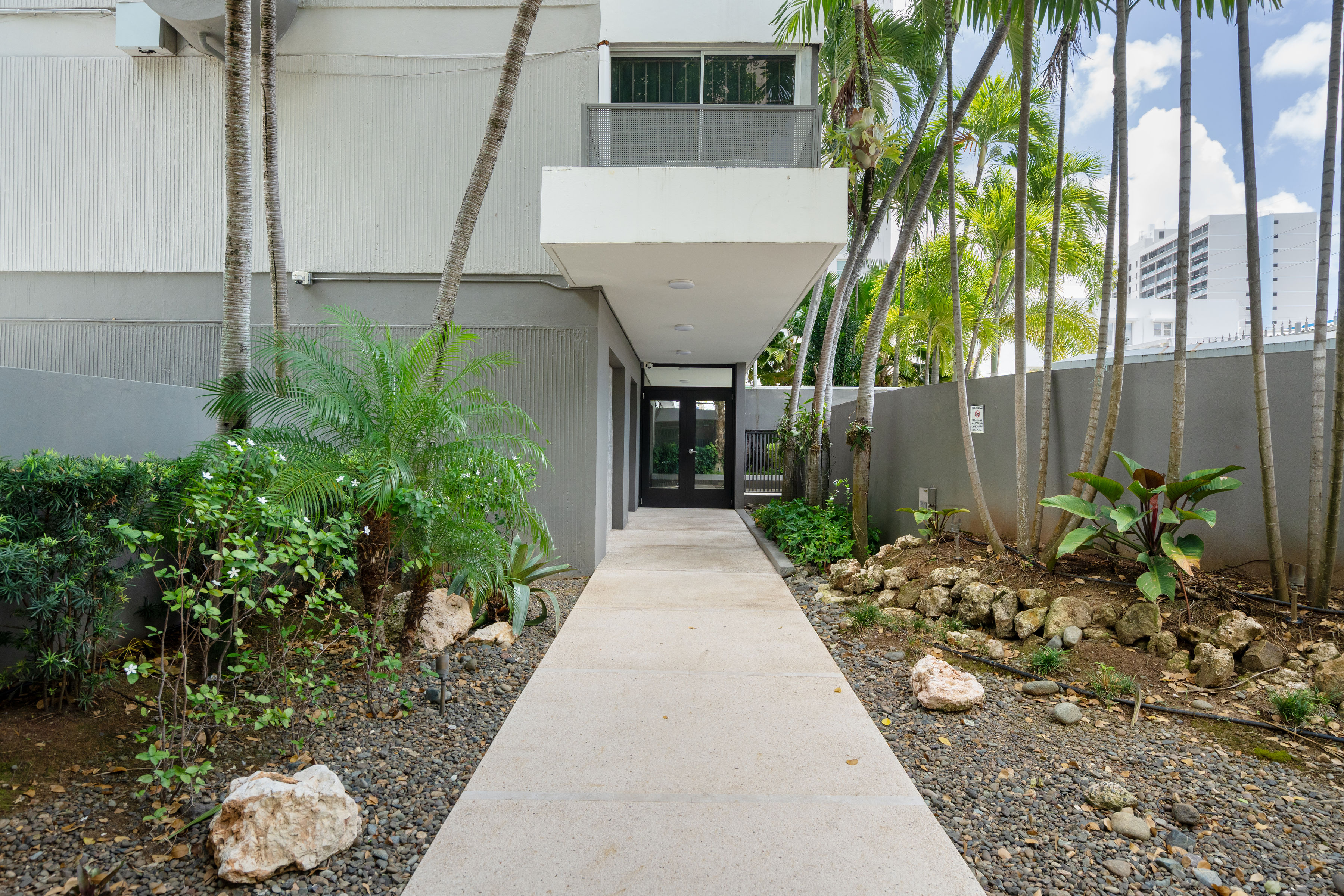 Kings Court 81 Condado | Landscaped entrance pathway leading to the Kings Court 81 condominium lobby