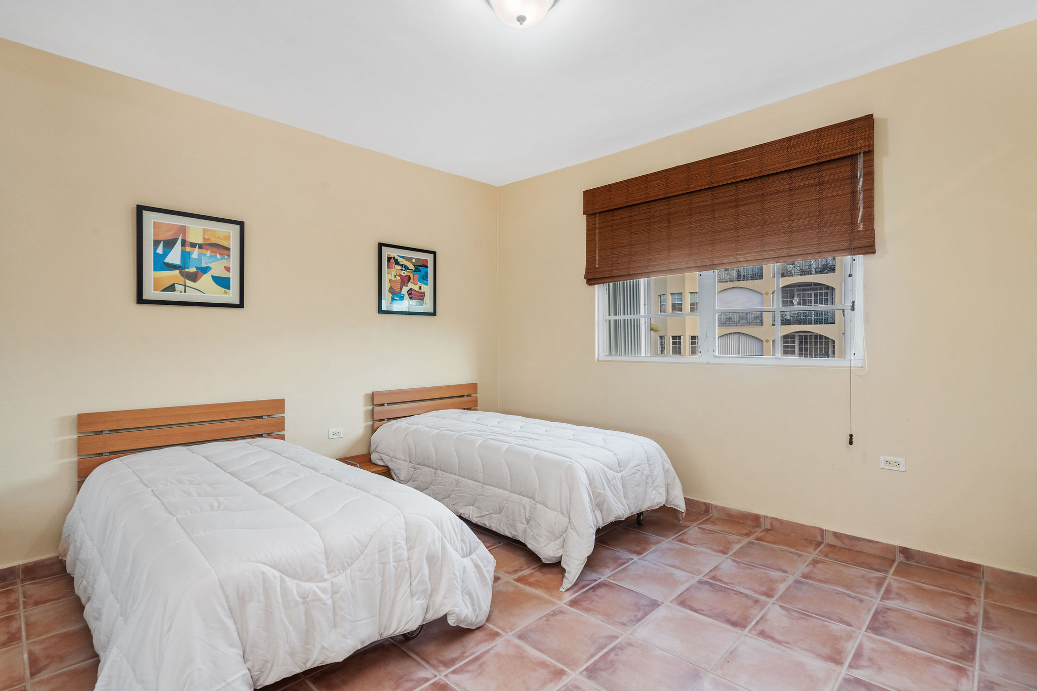 Royal Palm secondary bedroom with natural light and wood furnishings