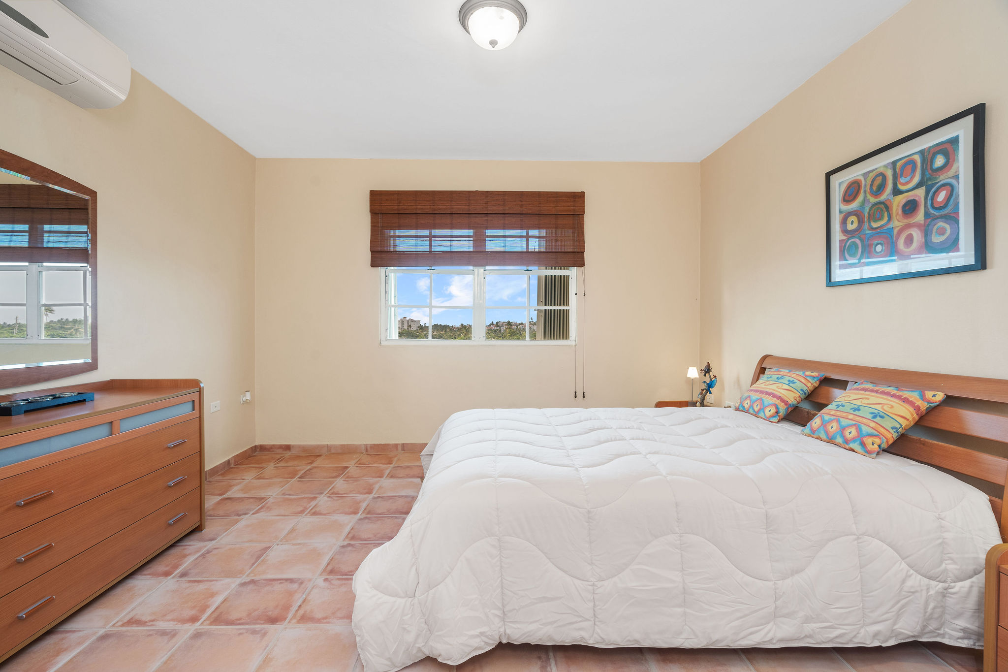 Royal Palm primary bedroom with natural light and wood furnishings