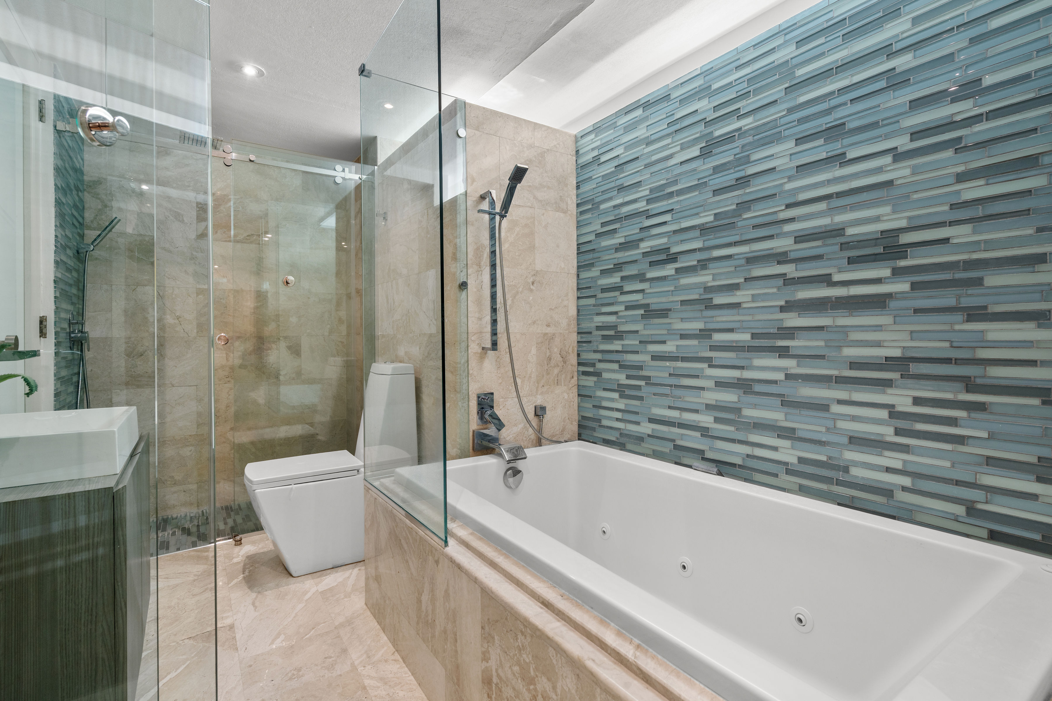 Las Olas Condado primary bathroom with soaking tub and glass-enclosed shower