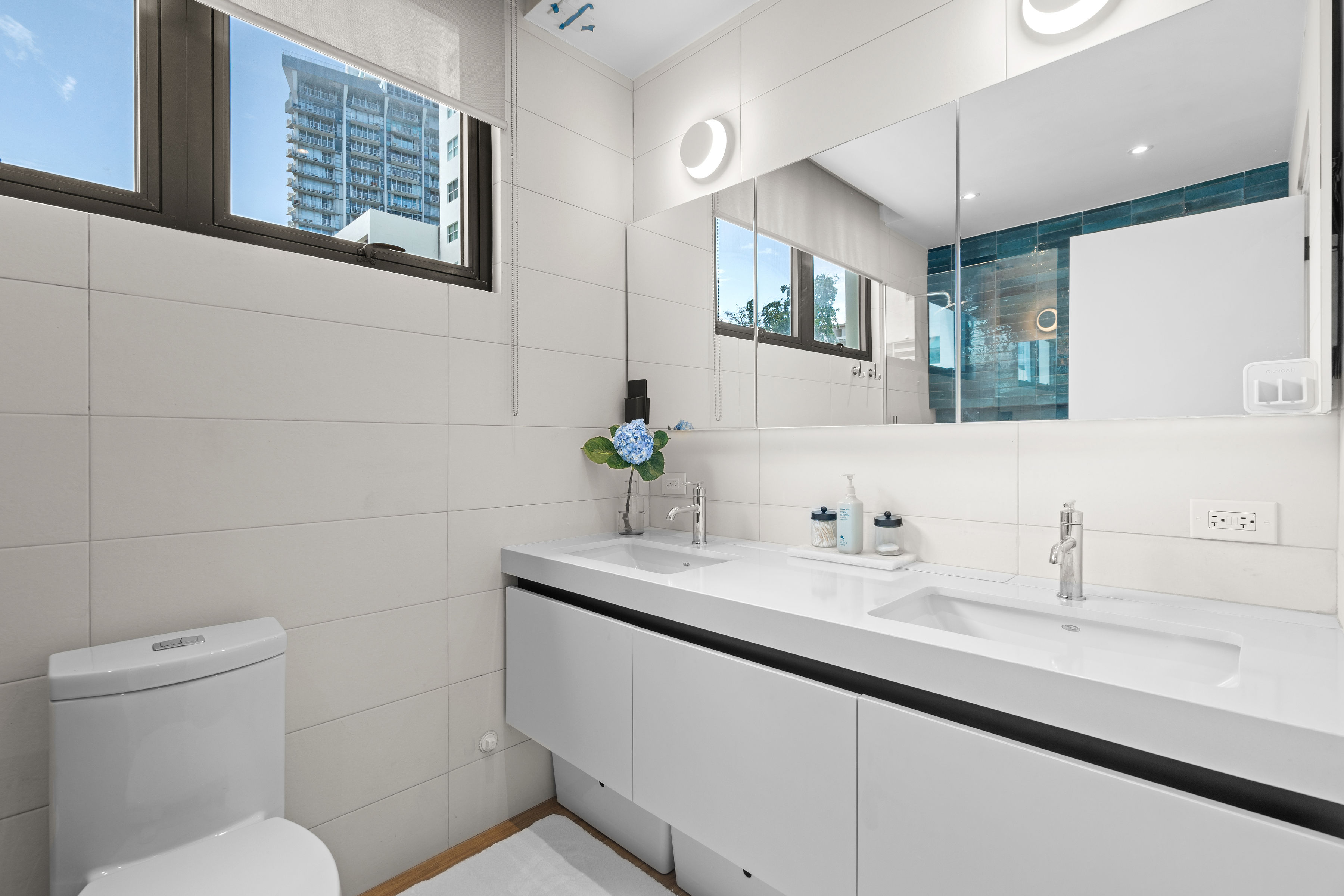 Casa Cervantes 2 | Contemporary bathroom with double vanity, mirrored cabinetry, and natural light