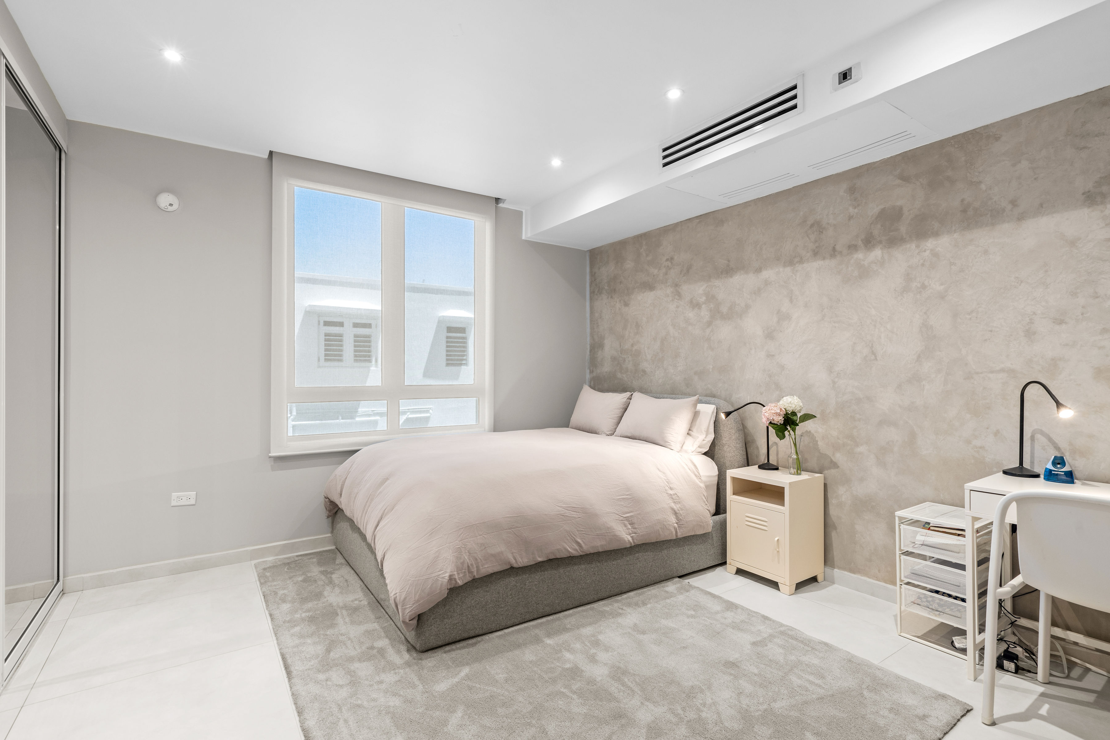 Casa Cervantes 2 | Secondary bedroom with textured feature wall, built-in closet, and workspace