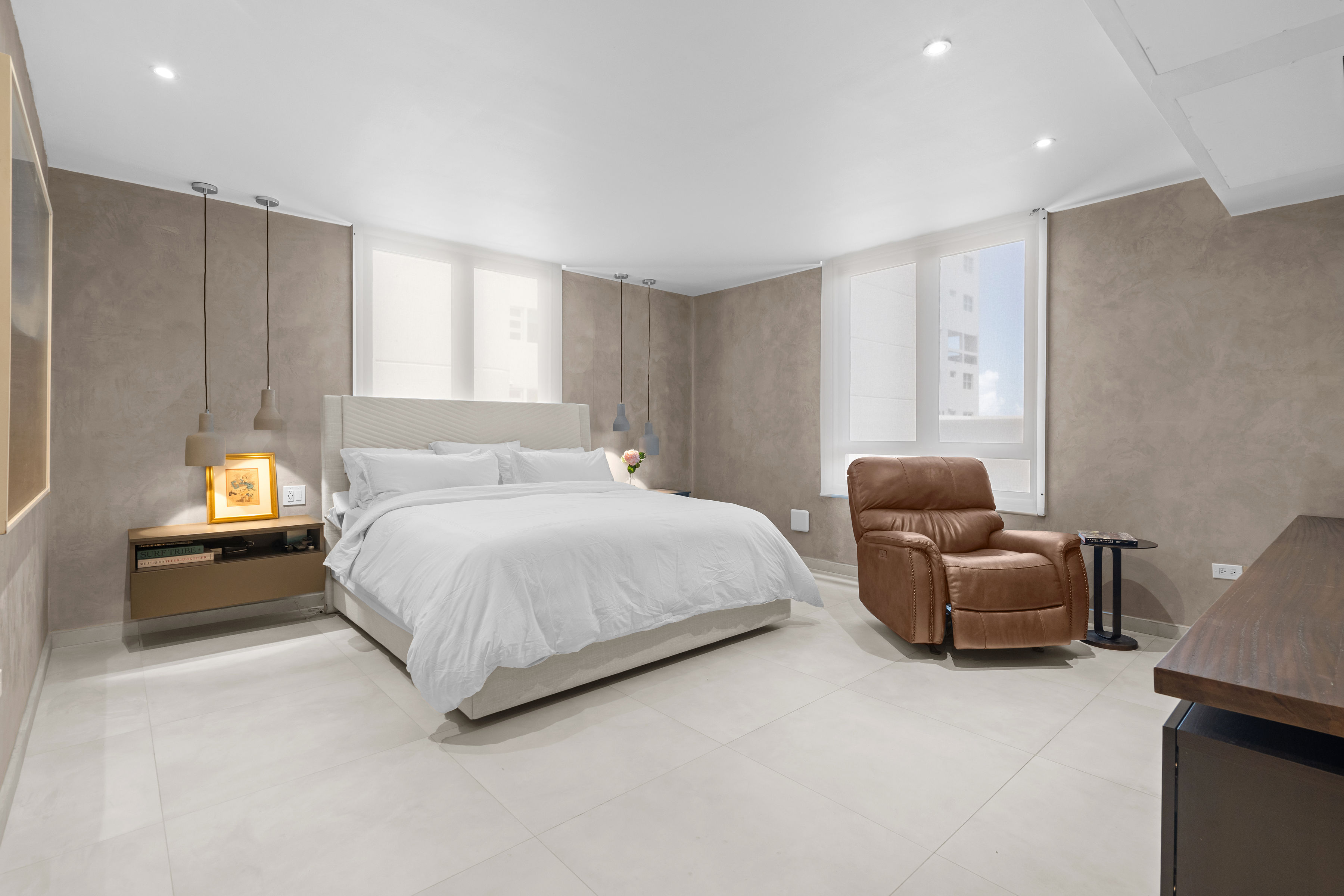Casa Cervantes 2 | Spacious primary bedroom with textured walls, pendant lighting, and abundant natural light