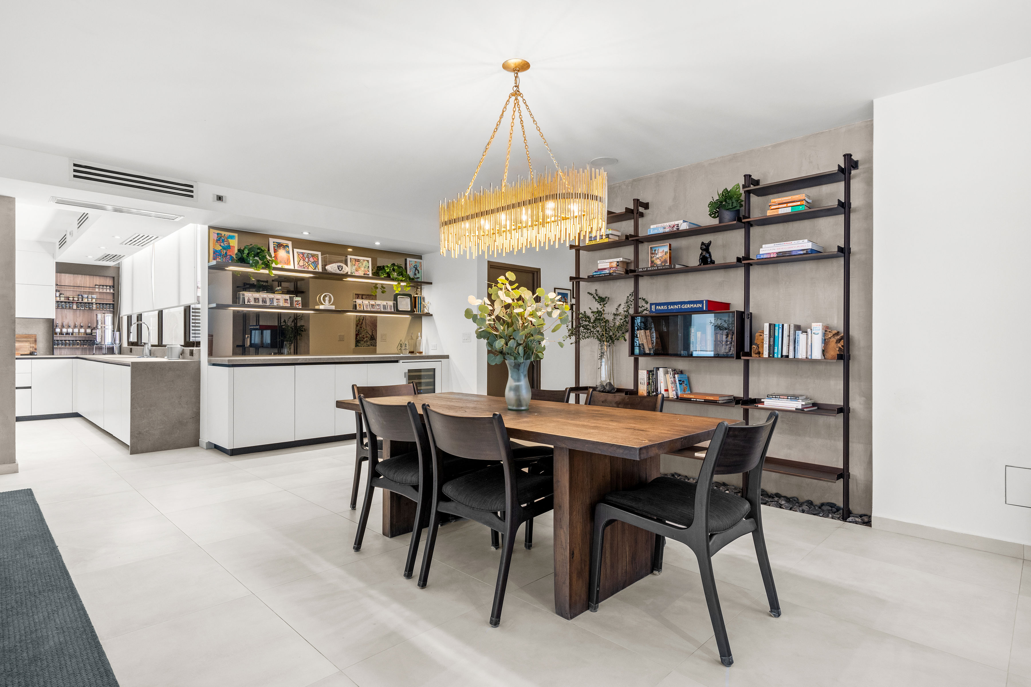 Casa Cervantes 2 | Open dining and living spaces with custom shelving and modern kitchen beyond
