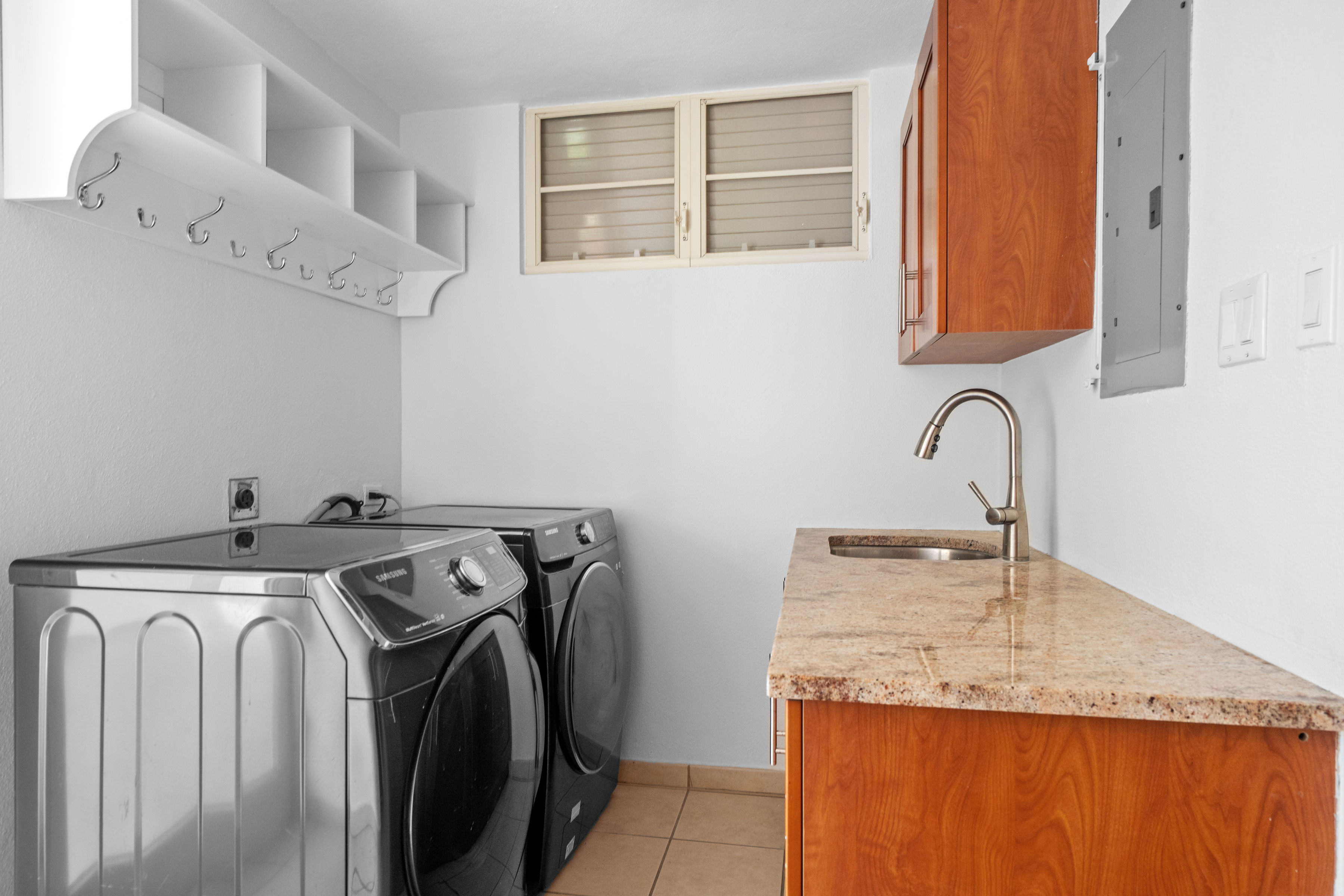 Sabanera Dorado 309 | Laundry room with washer, dryer, utility sink, and storage cabinetry
