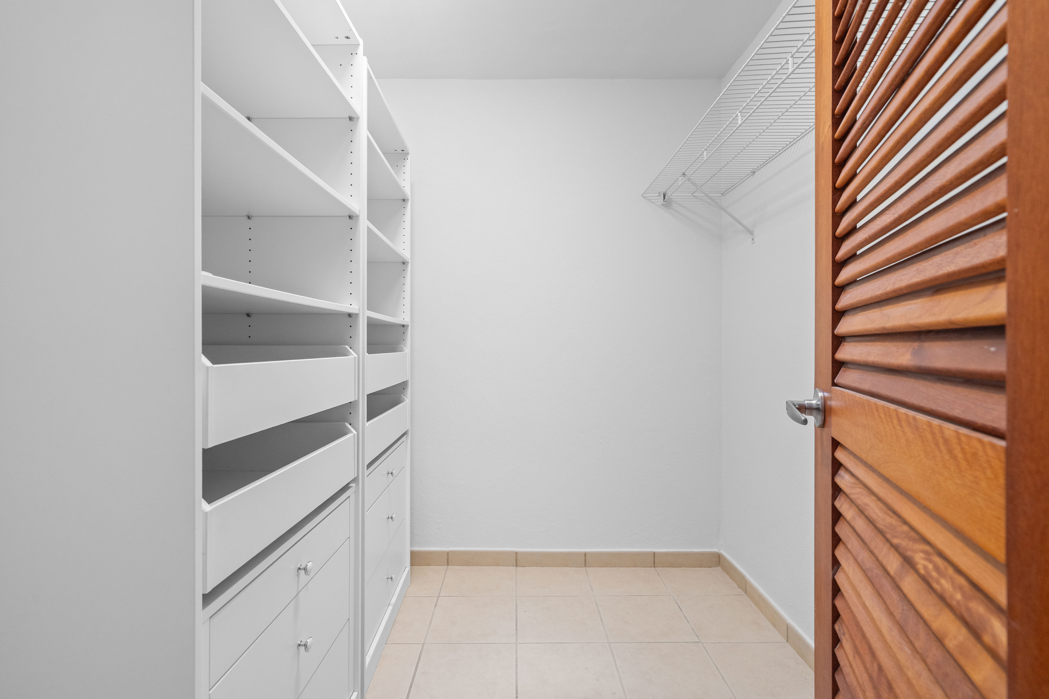 Sabanera Dorado 309 | Walk-in closet with built-in shelving and wood louvered door