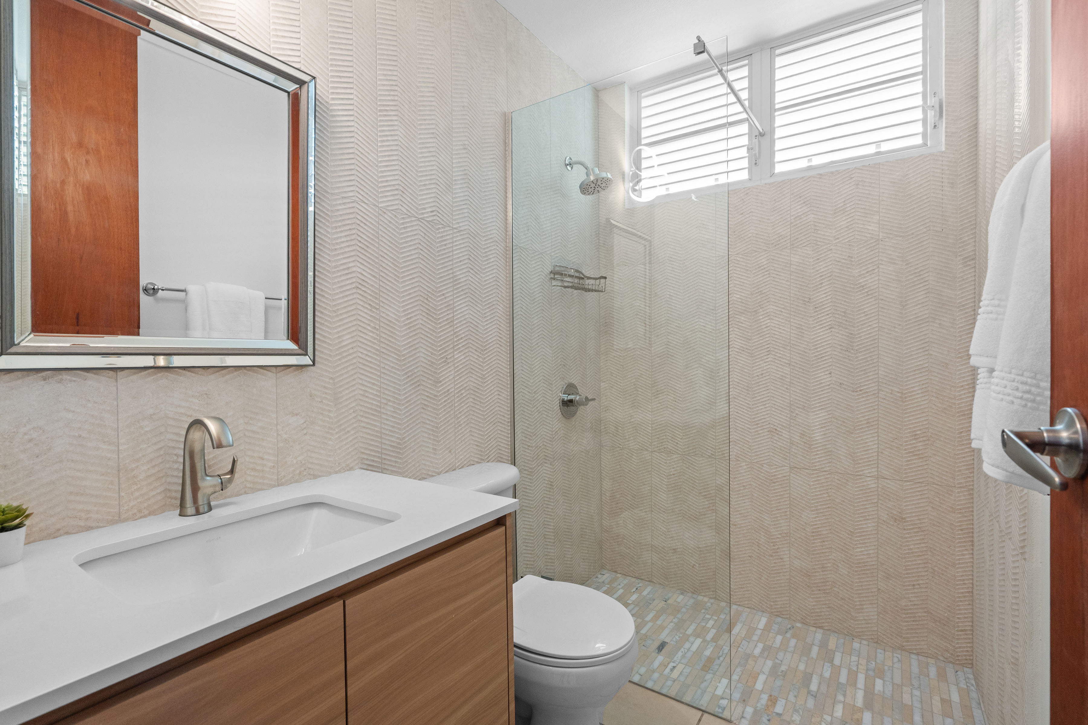 Sabanera Dorado 309 | Bathroom with wood vanity and glass-enclosed shower