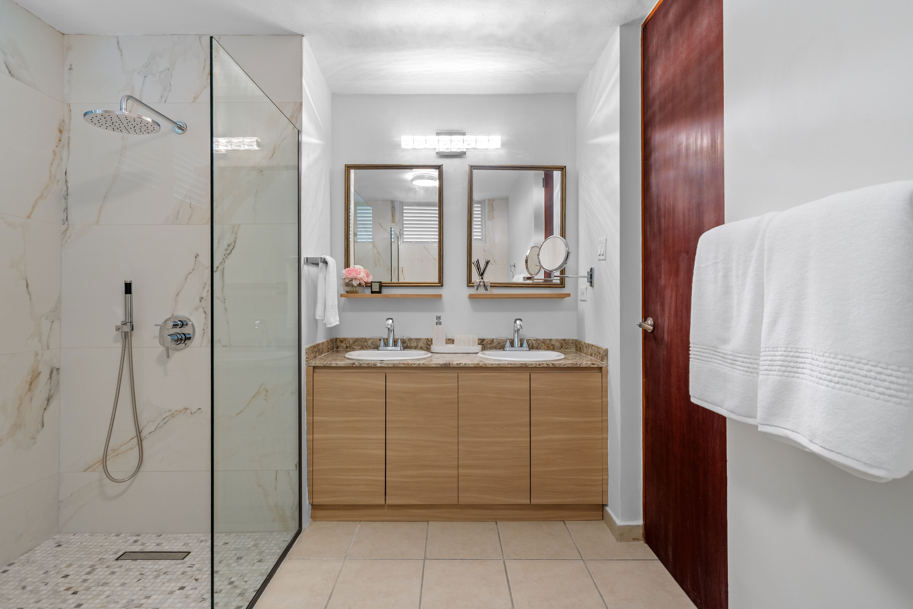 Sabanera Dorado 309 | Primary bathroom with double vanity and glass-enclosed walk-in shower