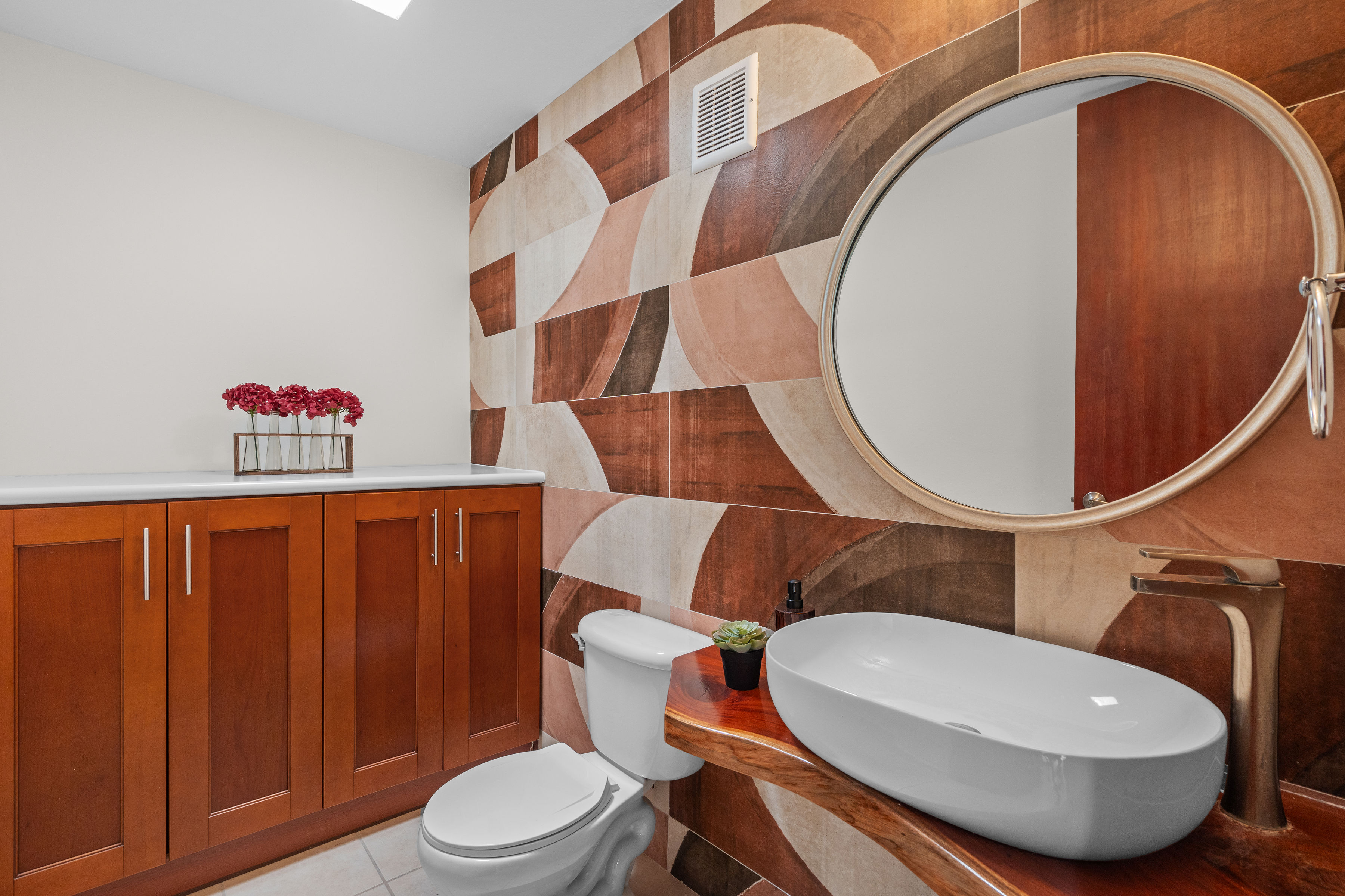 Sabanera Dorado 309 | Powder room with wood cabinetry, vessel sink, and patterned accent wall