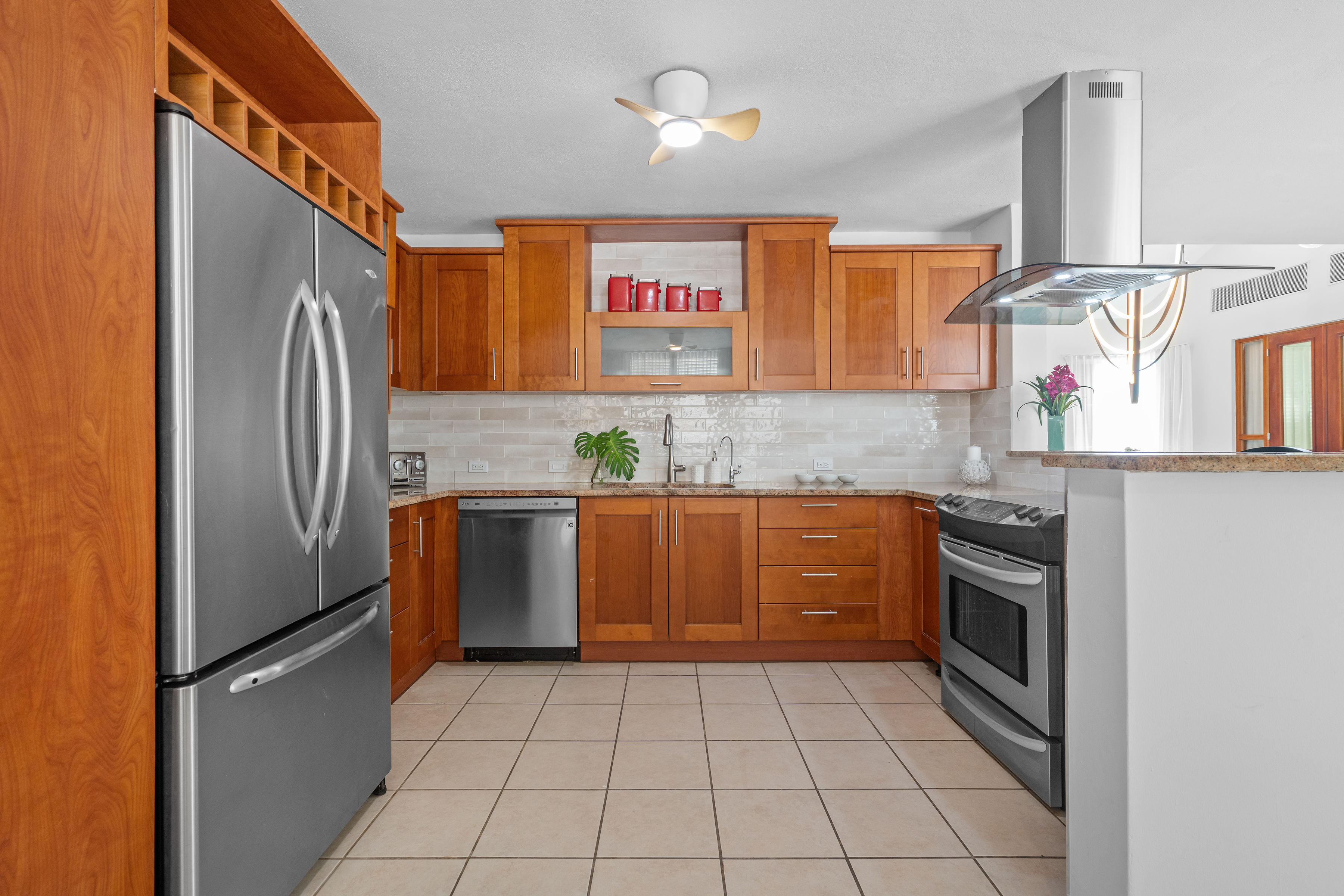 Sabanera Dorado 309 | Kitchen with warm wood cabinetry, stainless steel appliances, and breakfast counter