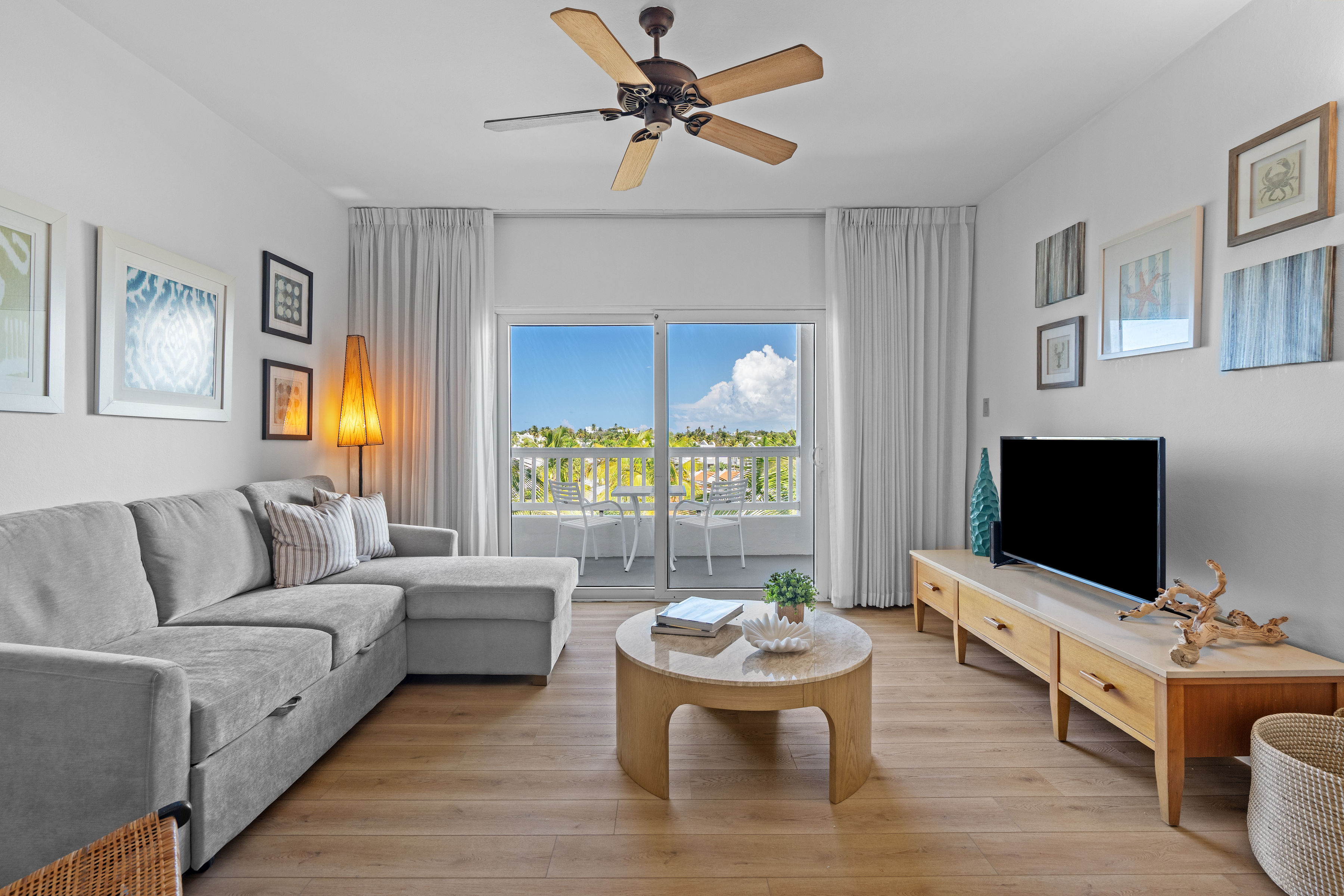 Embassy Villas, Dorado del Mar | Furnished living room with large window overlooking the coastal surroundings