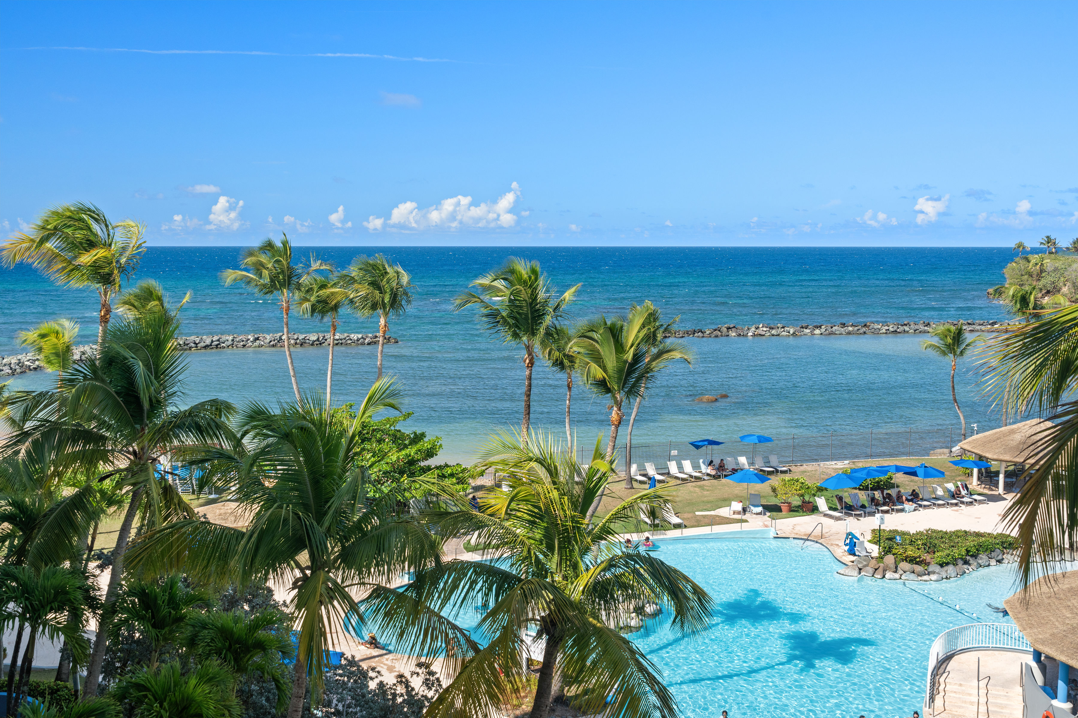 Embassy Villas, Dorado del Mar | Ocean and lagoon-style pool views framed by tropical landscaping