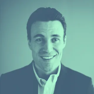 A man in a suit smiling for the camera.