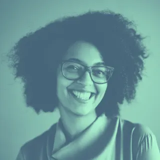A woman with glasses smiling for the camera.