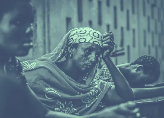 A woman is covering her head with a scarf.
