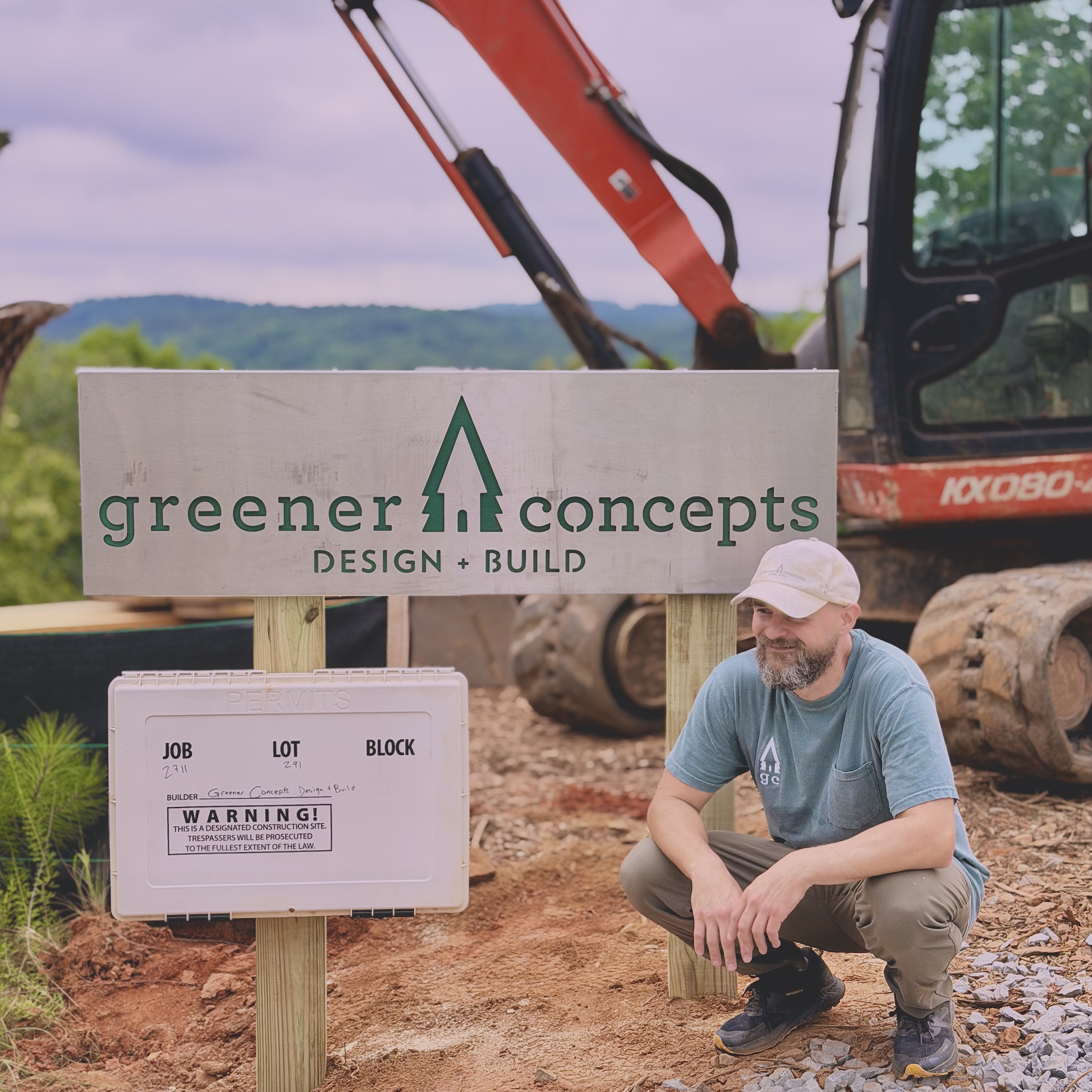 Max Mazur, founder of Greener Concepts Design + Build, at a custom home construction site in Alpharetta beside the Greener Concepts job sign and excavator