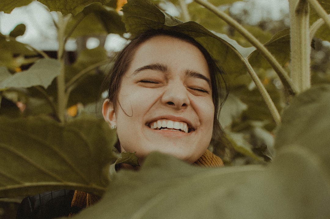 A person smiling and looking vibrant outdoors, implying long-term health - balanced mind and body massage