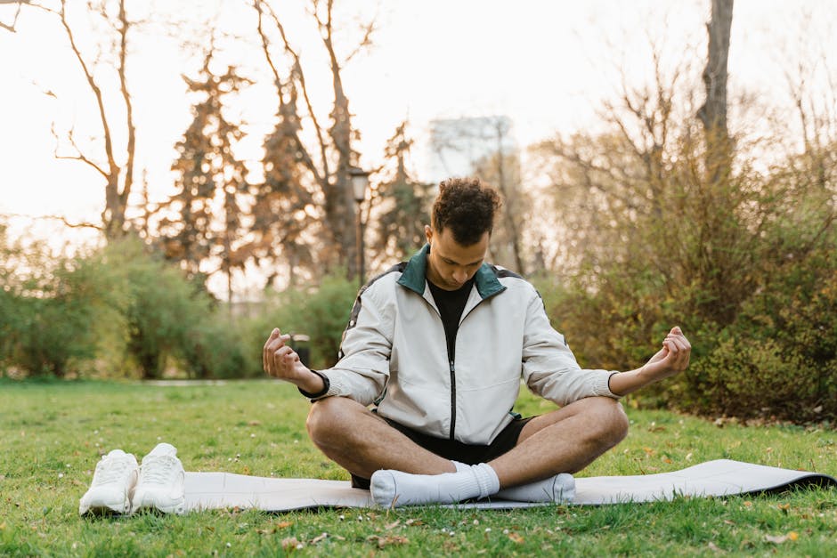 A person sitting in a calm pose, meditating outdoors with nature in the background - behavioral therapy for stress management