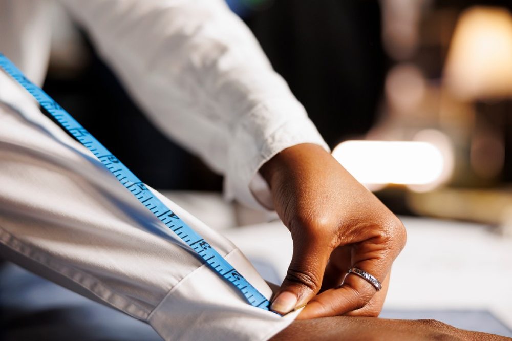 Stylist arranging a knit sweater and scarf on a mannequin