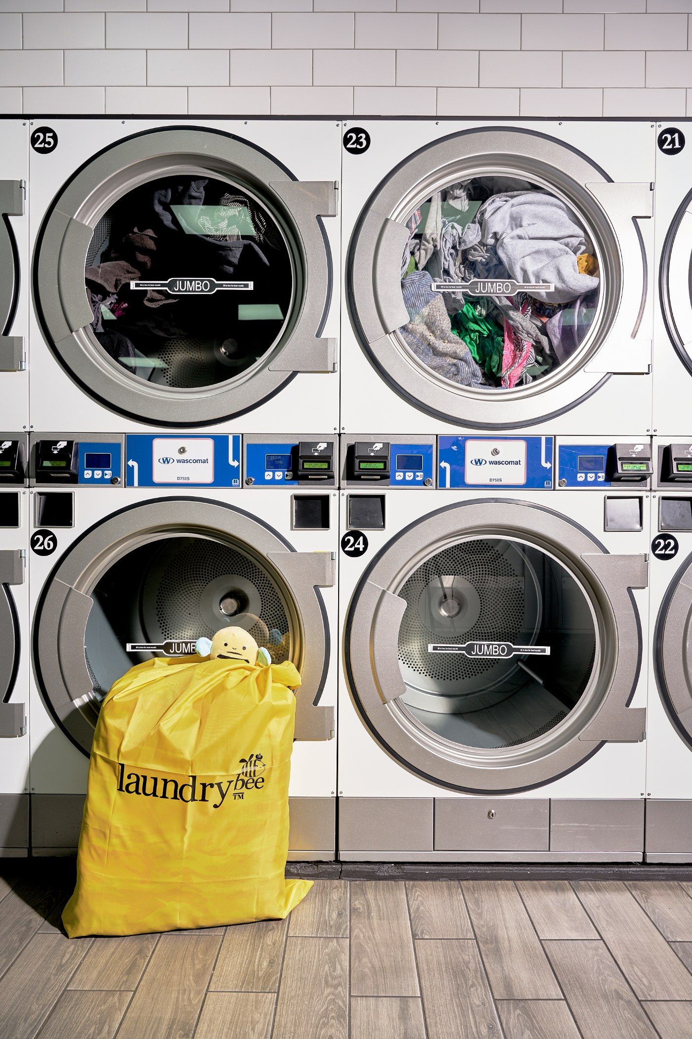 Yellow LaundryBee laundry bag in front of a wall of stacked washers